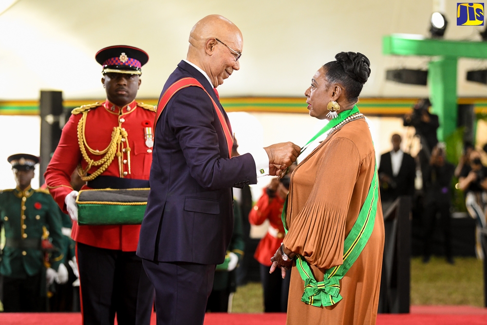 Governor-General, His Excellency, the Most Hon. Sir Patrick Allen (centre), presents Minister of Culture, Gender, Entertainment and Sport, Hon. Olivia Grange, with the the Order of Jamaica (OJ), during the 2022 National Honours and Awards ceremony, held at King’s House in Kingston on Monday (October 17).

