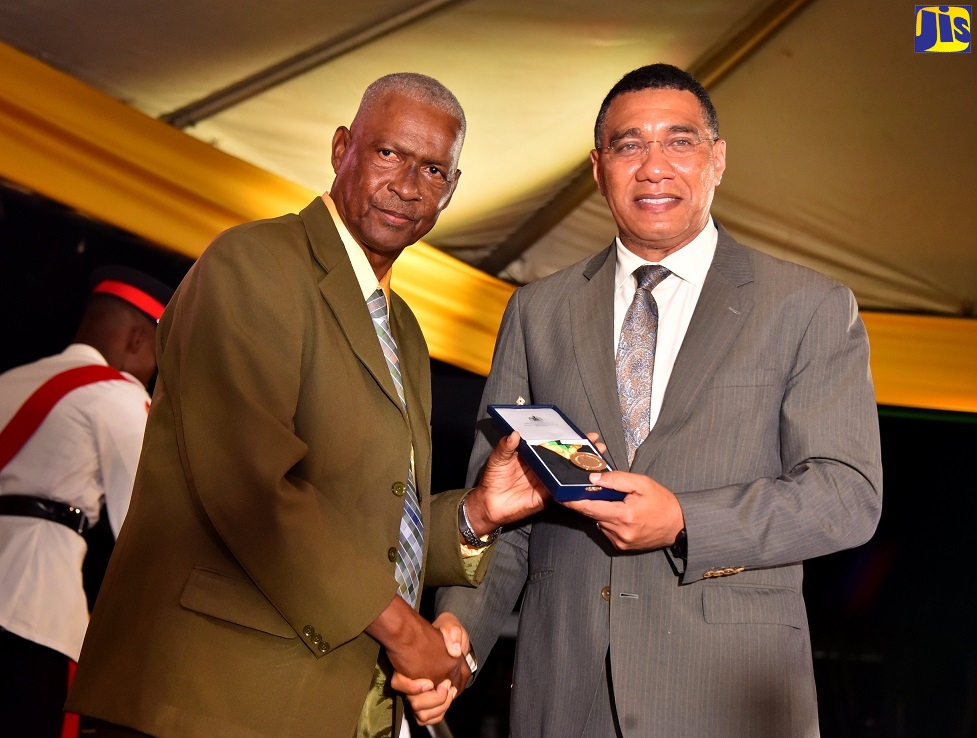 Prime Minister, the Most Hon. Andrew Holness (right), presents retired educator 67-year-old Devon Vassel with the Prime Minister’s Medal of Appreciation for Service to Education, during a ceremony held at Jamaica House, on September 8.