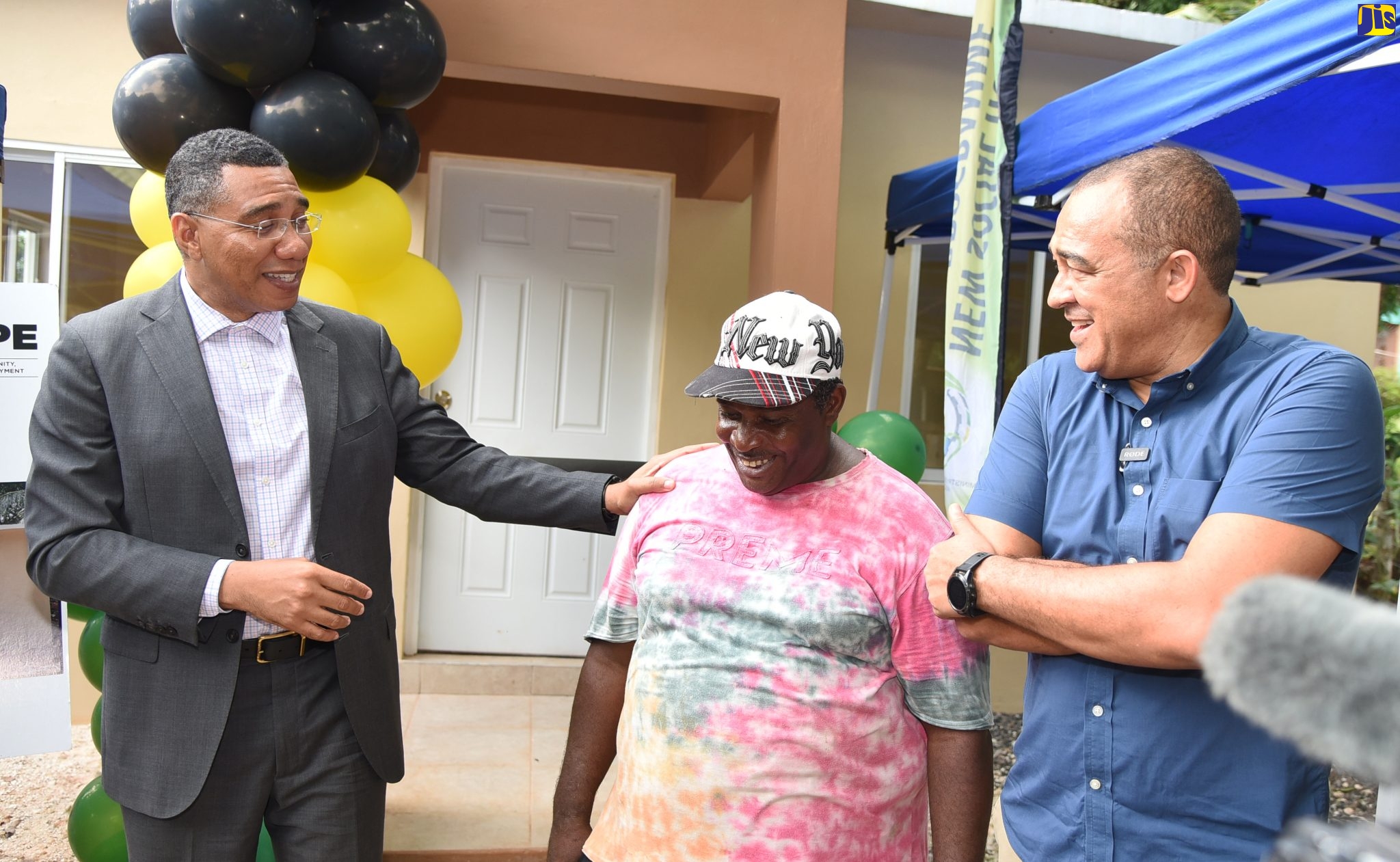 Prime Minister, the Most Hon. Andrew Holness (left), engages with Patrick Watson (centre) of Cudjoe’s Hill, St. Catherine, who is the beneficiary of a new home under the New Social Housing Programme (NSHP). Member of Parliament for St. Catherine West Central, Dr. the Hon. Christopher Tufton (right), shares the moment.  Occasion was Wednesday’s (October 12) ribbon-cutting ceremony to officially hand over a new three-bedroom unit to Mr. Watson, marking the delivery of the 100th housing unit under the NSHP. The programme, conceptualised by Prime Minister Holness and implemented in 2018, is designed to improve the housing condition of the country’s poor and disadvantaged population by providing quality affordable and sustainable housing.