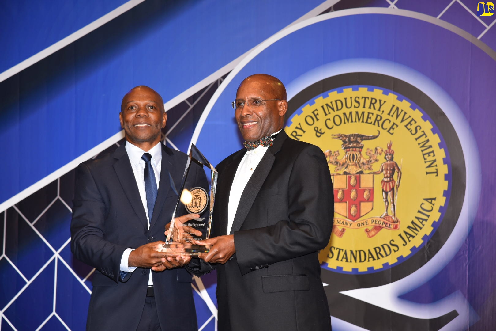 Minister of Industry, Investment and Commerce, Senator the Hon. Aubyn Hill (right) presents General Manager, Dairy Industries Jamaica Limited, Radcliffe Walker with the National Quality Award during the Bureau of Standards Jamaica’s (BSJ)  National Quality Awards Ceremony and Banquet on October 13 at the Jamaica Pegasus Hotel, Kingston.