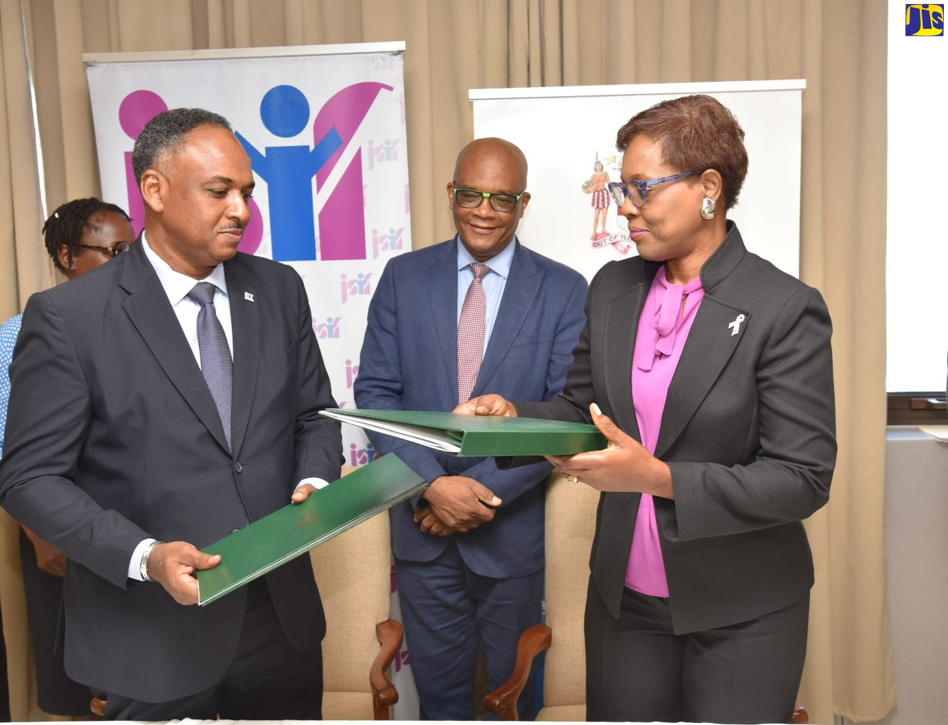Permanent Secretary in the Ministry of Foreign Affairs and Foreign Trade, Ambassador Sheila Sealy Monteith (right) and Managing Director, Jamaica Social Investment Fund (JSIF), Omar Sweeney (left), with signed documents formalising the agreement between the Ministry and JSIF for the diaspora to be more involved in community development projects through JSIF.  The signing took place on Wednesday (October 19) at the Ministry’s office, 2 Port Royal Street, downtown Kingston. Sharing  the moment is State Minister in the Ministry of Foreign Affairs and Foreign Trade, Senator the Hon. Leslie Campbell.