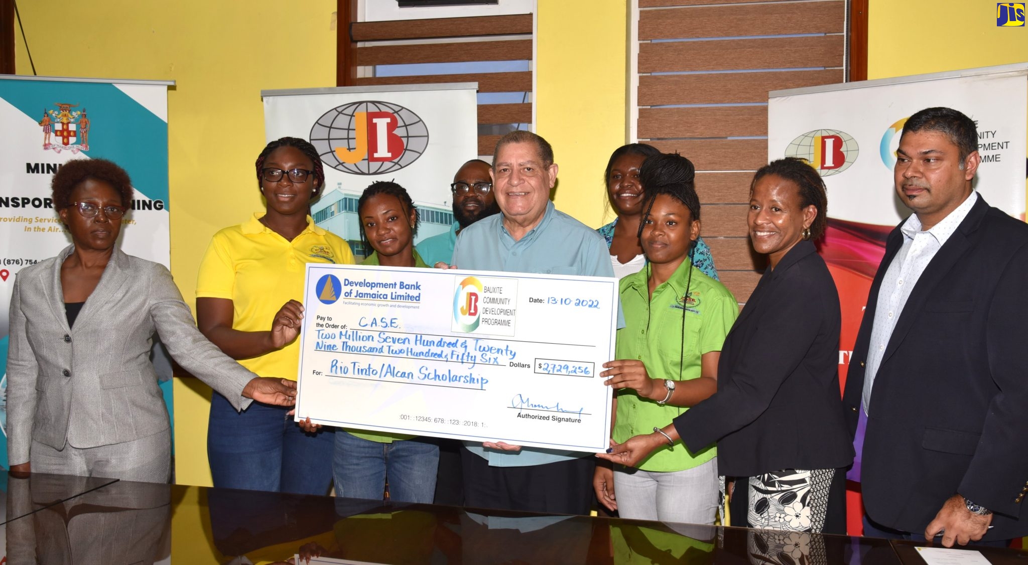 Minister of Transport and Mining, Hon. Audley Shaw (centre), participates in the handover of a cheque valued at more than $2.7 million to four students who are pursuing studies at the Portland-based College of Agriculture Science and Education (CASE). Occasion was the presentation of the Rio Tinto/Alcan Legacy Fund Agriculture Scholarship at the Ministry in Kingston on October 13.  The students are Tamoi McLean (second left); Daunja Galloway (third left) and Celine Sitladeen (third right). Absent is Vanessa McMurrine. Sharing in the presentation are Acting General Manager, Jamaica Bauxite Institute (JBI), Joan Thomas Levy (left); Chairman, Rio Tinto/Alcan Legacy Fund Board, Sherene Golding Campbell (second right); and Principal Director, Mining/Minerals (Acting) in the Ministry, Suresh Bhalai (right).  In the background are Director of Bauxite Lands, Jamaica Bauxite Institute (JBI), Kemoy Lindsay; and Programme Executioner, Development Bank of Jamaica (DBJ, Pamela Nesbeth.