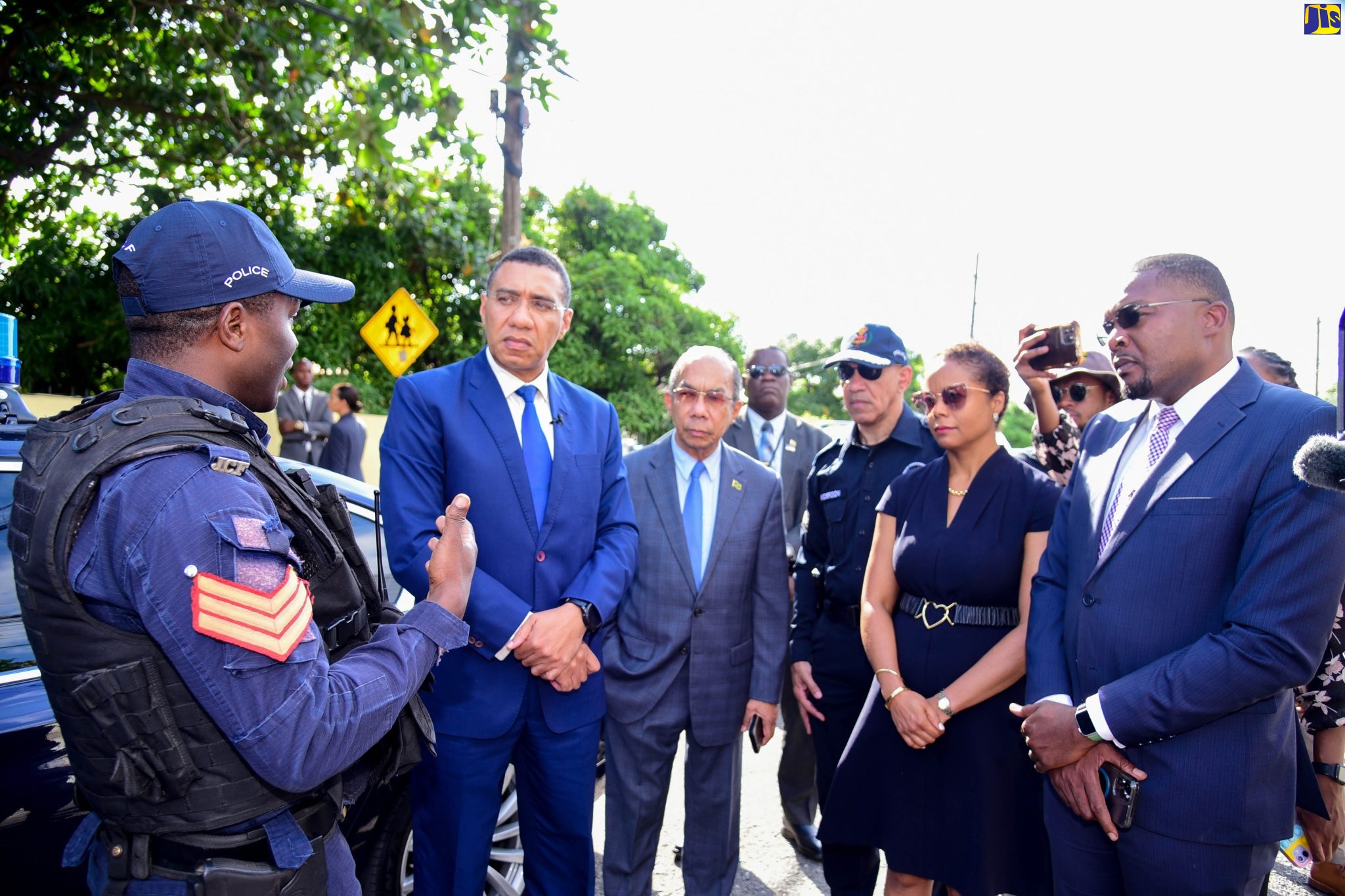 Prime Minister, the Most Hon. Andrew Holness (second left), is given an update on activities in the Kingston Eastern Police Division by Sergeant Marvin Wallace (left), during a visit with members of the security forces stationed at a State of Public Emergency (SOE) checkpoint within the area, on Monday (November 28). Also listening (from third left) are Deputy Prime Minister and National Security Minister, Hon. Dr. Horace Chang; Police Commissioner, Major General Antony Anderson; Minister of Legal and Constitutional Affairs, Hon. Marlene Malahoo Forte; and Minister without Portfolio in the Office of the Prime Minister (OPM) with Responsibility for Information, Hon. Robert Morgan.