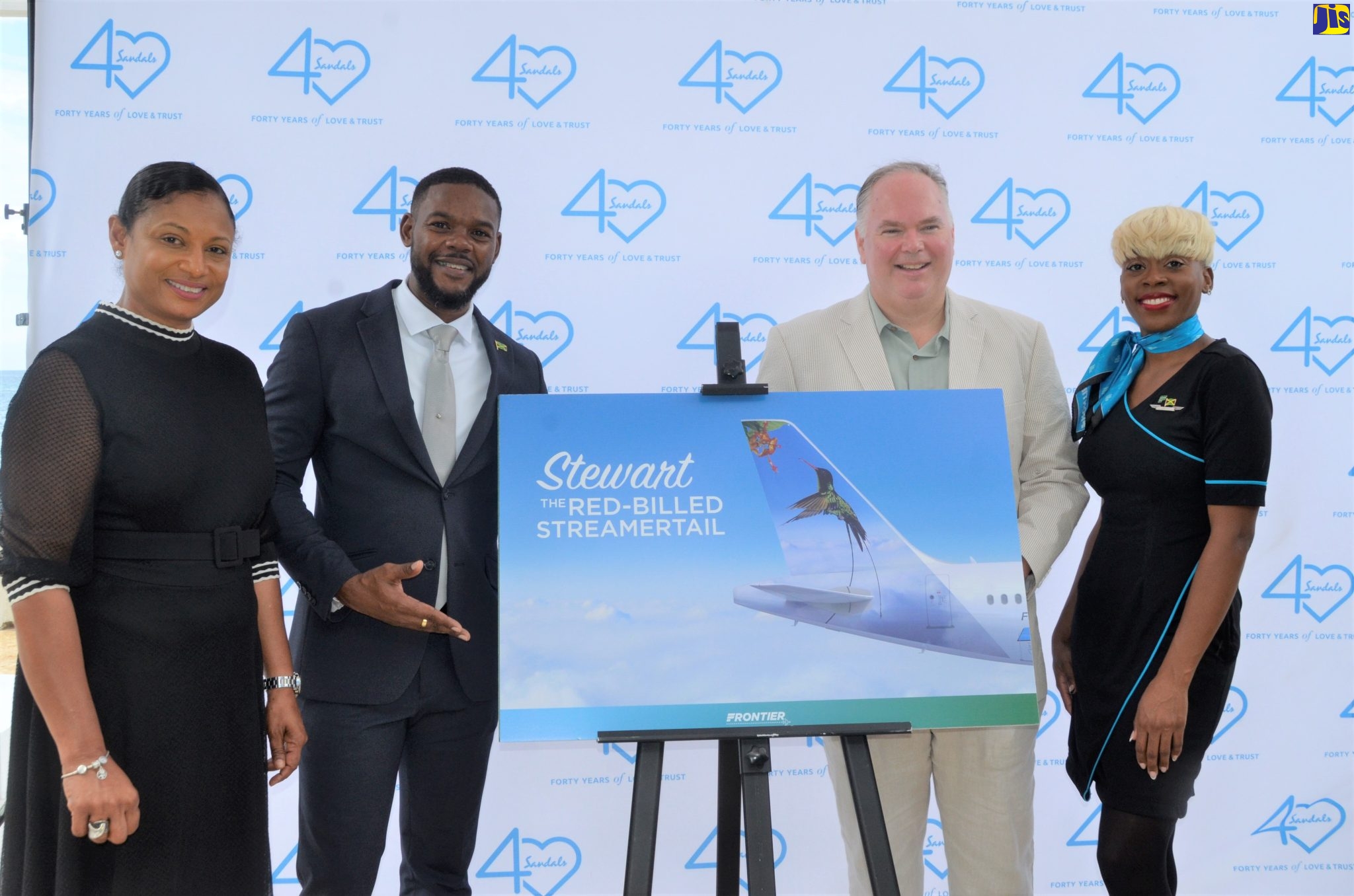 Chief Executive Officer (CEO) of Frontier Airlines, Barry Biffle (second right), displays an image of the Hummingbird that will adorn the tail of one of its aircraft, during a ceremony to announce a new partnership with destination Jamaica, held at Sandals Montego Bay, St James, on Thursday (November 10). He is joined by (from left) Regional Director, Jamaica Tourist Board (JTB), Odette Dyer; Deputy Mayor of Montego Bay, Councillor Richard Vernon, and Frontier Airlines Flight Attendant, Kadesha Smith.
