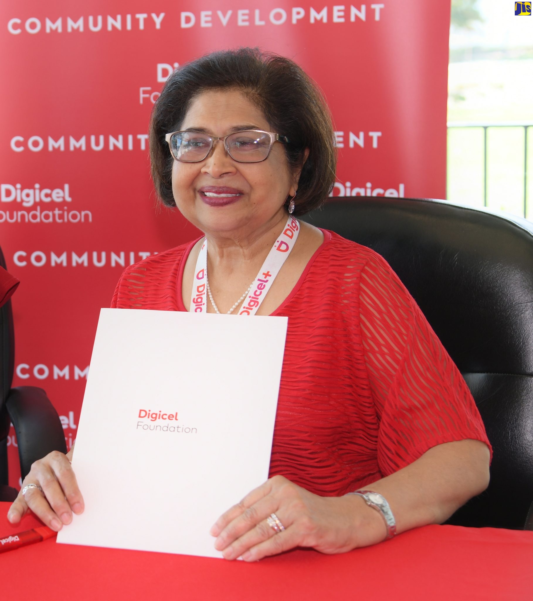 Chairman of the Digicel Foundation, Jean Lowrie-Chin, displays a grant document, during a ceremony for the award of grant support to community groups, held recently at the entity’s head office, downtown Kingston.