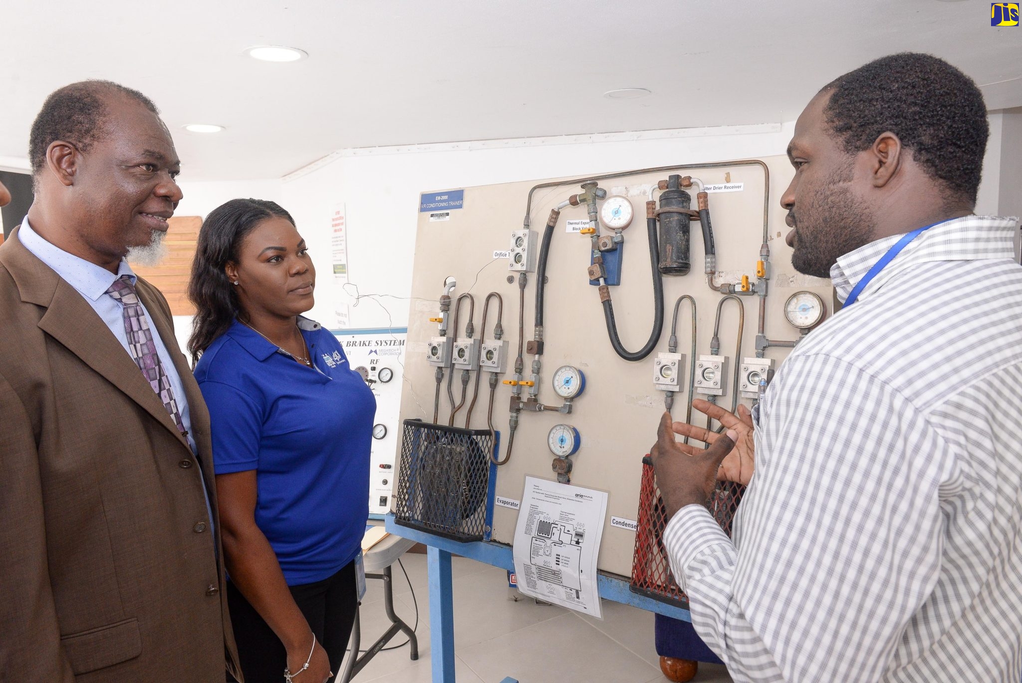 Assistant Chief Education Officer,  Ministry of Education and Youth,  Sadpha Bennett (left) and Director of Programmes, HEART/NSTA Trust, Ronique Rhoden, listen as Instructor Jamaican-German Automotive School (JAGAS), Francois Johnson,  outlines the features of an air-conditioning trainer. Occasion was the HEART/NSTA’s Youth Festival held on November 23 at the Jamaica Conference Centre, downtown Kingston.