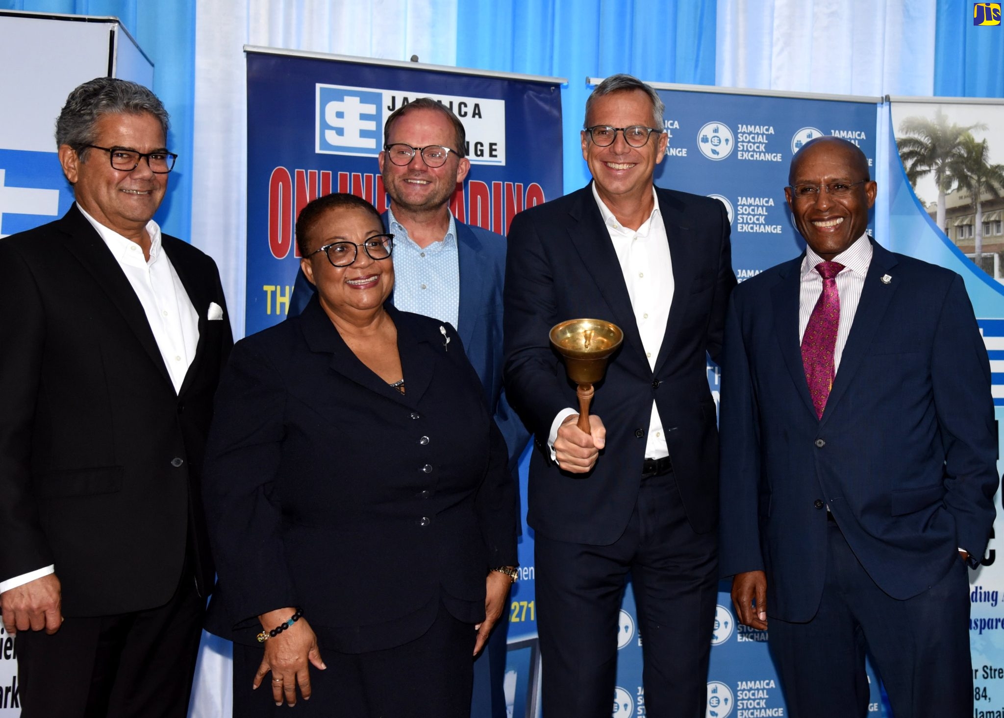 Minister of Industry, Investment and Commerce, Senator the Hon. Aubyn Hill (right), looks on as Managing Director, Dutch Caribbean Securities Exchange (DCSX) Dirk-Jan de Graaff (second right), rings a bell signalling the opening of the DCSX and the Jamaica Stock Exchange (JSE), which have collaborated on capital market activities, being facilitated under a Memorandum of Understanding (MOU). Also looking on (from left) are Chief Executive Officer, DCSX, Rene Romer; Managing Director, JSE, Dr. Marlene Street Forrest; and Board Member, DCSX, Walter Blijleven. Occasion was a bell-ringing and MOU signing ceremony at the JSE in Kingston, on Tuesday (November 22).