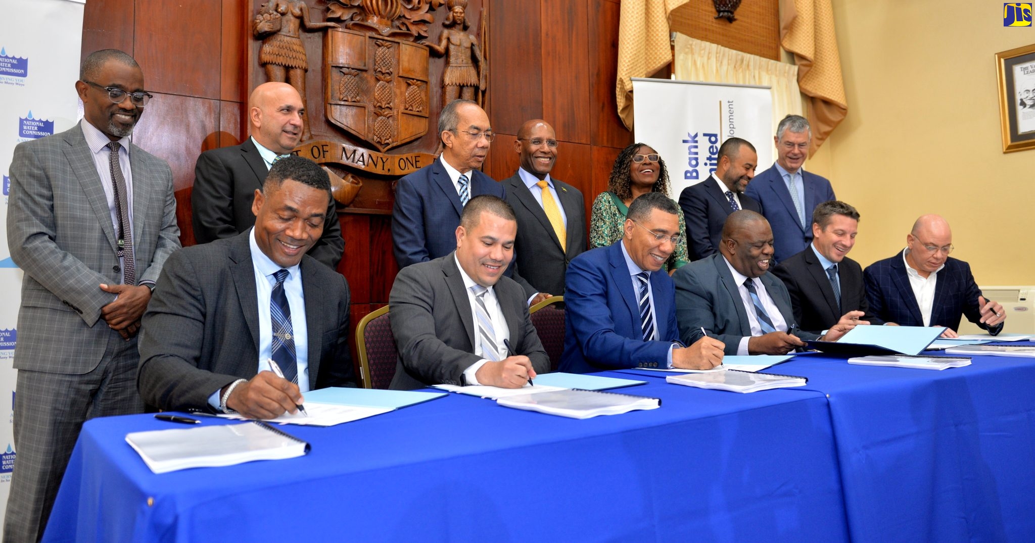 Prime Minister, the Most Hon. Andrew Holness (third left, seated), signs the Rio Cobre Public-Private Partnership Agreement for the construction of a new Water Treatment Plant in Content, St. Catherine, at Jamaica House in Kingston, on Wednesday (November 23). Also signing are (from left) President, National Water Commission (NWC), Mark Barnett; Minister without Portfolio in the Office of the Prime Minister, Senator the Hon. Matthew Samuda; Chairman, NWC, Michael Shaw; Managing Director, Vinci Construction Grands Projects, Timothée Delebarre and Chief Executive Officer (CEO), Jamaica Producers Group Limited, Jeffery Hall. Witnessing the signing (from left) are Managing Director, Development Bank of Jamaica (DBJ), Anthony Shaw; President and Chief Executive Officer, Sagicor Group Jamaica Limited, Christopher Zacca; Deputy Prime Minister, Hon. Dr. Horace Chang; Minister of Industry, Investment and Commerce, Senator the Hon. Aubyn Hill;  Permanent Secretary in the Ministry of Economic Growth and Job Creation, Audrey Sewell; Managing Director, Eppley Limited, Nicolas Scott, and Director of Asia and Building Division and Water Works, Vinci Construction Grands Projects, Yanick Garillon. 