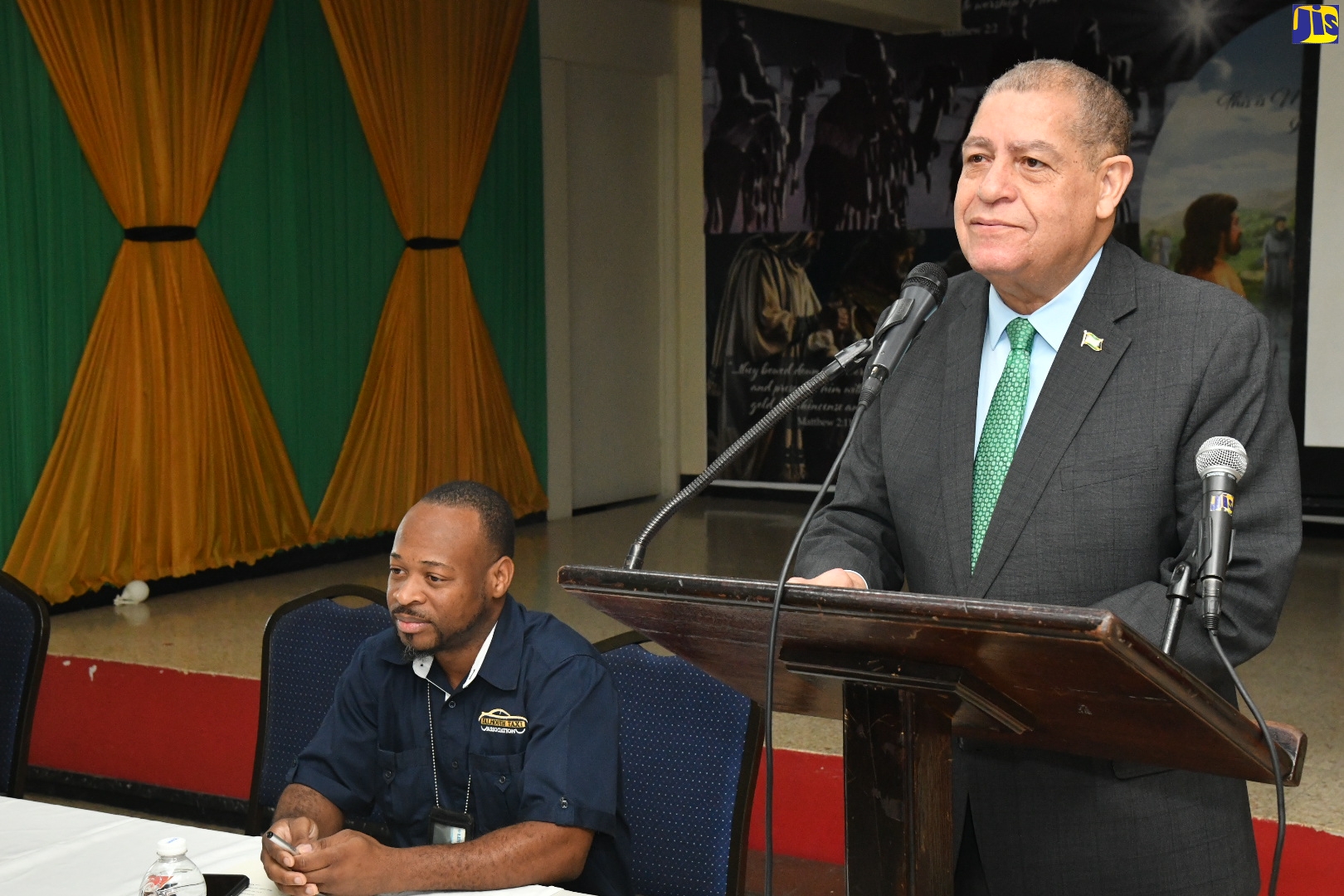 Minister of Transport and Mining, Hon. Audley Shaw, addressing the Transport Operators Development Sustainable Services (TODSS) road-safety round table on Thursday (December 8), at the Boulevard Baptist Church, Kingston. Seated is President of the Falmouth Taxi Association, Sheldon Malcolm.