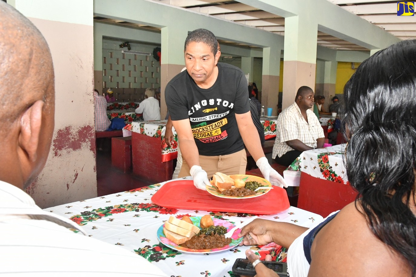 Mayor of Kingston, Senator Councillor Delroy Williams, serves breakfast to several persons living on the streets of the Corporate Area, who were catered to during the Mayor’s Annual Christmas Day Feeding of the Homeless treat on Sunday (December 25), at the Marie Atkins Night Shelter on Hanover Street, downtown Kingston. The activity, which is one aspect of the Kingston and St. Andrew Municipal Corporation’s (KSAMC) Homeless Programme, is coordinated by the organisation’s Poor Relief Department.