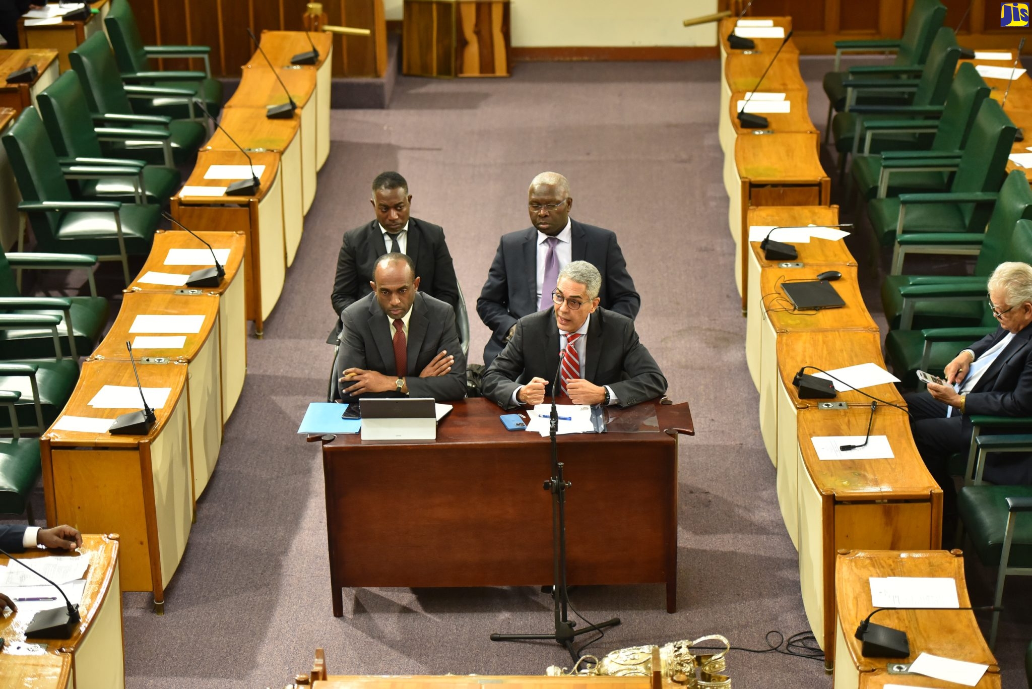 Governor, Bank of Jamaica, Richard Byles (right), delivers a monetary policy statement during a meeting of the Standing Finance Committee of the House of Representatives on Wednesday, December 14. He is joined by Senior Deputy Governor, Dr. Wayne Robinson (to his right);  and Deputy Governors, Dr. Jide Lewis (left, background)  and Robert Stennett.