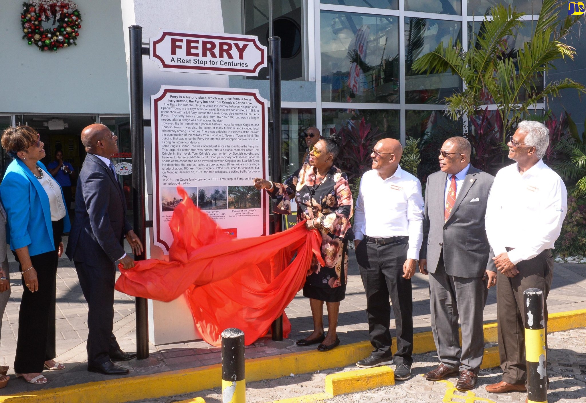Minister of Culture, Gender, Entertainment and Sport, Hon. Olivia Grange (third left), and Minster of Industry, Investment and Commerce, Senator the Hon. Aubyn Hill (second left)  unveil a sign detailing the history of the site of the newly opened Coore’s Ferry FESCO Service Station on Mandela Highway on December 13. Others are, from left, Managing Director, Coore's Limited,  Monica Coore; Chairman, Coore’s Limited, Hugh Coore; Member of Parliament, St. Andrew Western, Anthony Hylton; and FESCO Director, Lyden Heaven.