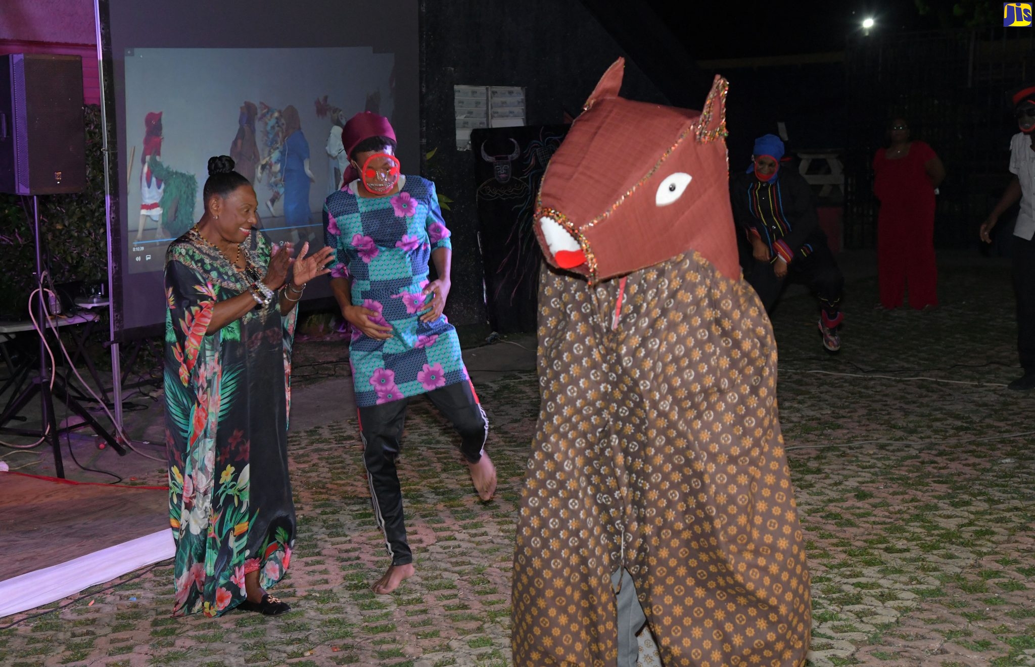 Minister of Culture, Gender, Entertainment and Sport, Hon. Olivia Grange (left), enjoys a performance by Jonkonnu characters, Belly Woman (centre) and Horse Head from the Excelsior Performing Arts Society at the Excelsior Community College. Occasion was the media launch of the Jonkonnu Road March and Competition on Tuesday (December 20) at the Courtyard, Louise Bennett Garden Theatre in Kingston.
