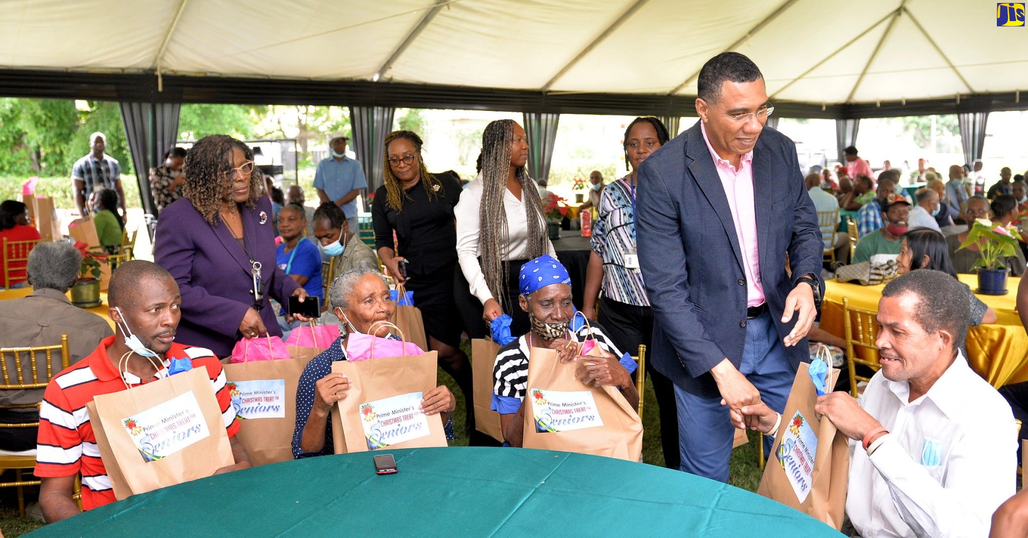 Prime Minister, the Most Hon. Andrew Holness (second right), greets a resident of the Marie Atkins Night Shelter. Looking on are other residents of the facility who also received gift packages from the Prime Minister. The occasion was the Office of the Prime Minister (OPM) end-of-year senior citizens treat. The event was held on the lawns of the OPM, on Wednesday (December 14).