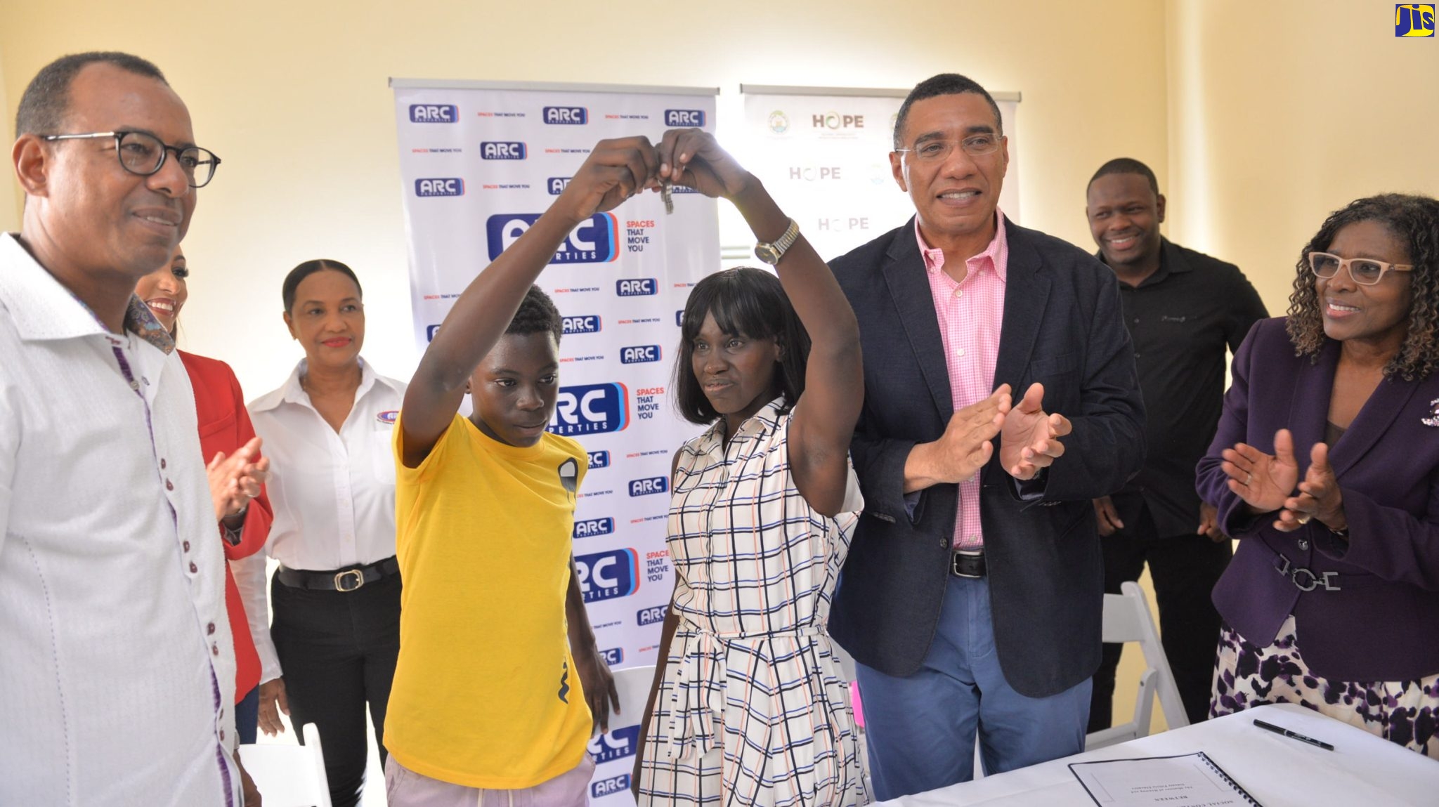 Prime Minister, the Most Hon. Andrew Holness (third right), applauds as new beneficiary, Sidonie Eldemire (fourth right), and son Rohan Clarke (fourth left), display the keys to their home, which they received under the New Social Housing Programme. The unit was constructed and donated by Arc Properties Limited.  Looking on (from left) are Arc Properties Chairman, Norman Horne, General Manager, Ashley-Ann Foster Horne, and Deputy Chairperson, Charlotte Hayles; Chief Executive Officer, Kinetic Engineering Services Limited, Keon Hinds, and Permanent Secretary in the Office of the Prime Minister and the Ministry of Economic Growth and Job Creation, Audrey Sewell. The presentation was made on Wednesday, (December 14).