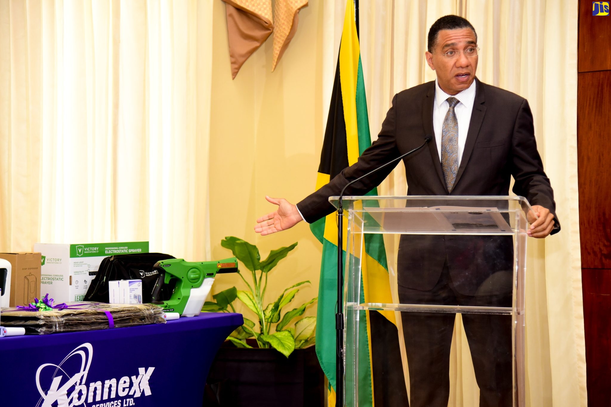 Prime Minister, the Most Hon. Andrew Holness, points to sanitisation and hygiene supplies that have been donated to the Ministry of Health and Wellness by Konnexx Services Limited for distribution to 26 hospitals to aid in the fight against viral and bacterial infections. The items were presented at ceremony at Banquet Hall, Jamaica House, on January 18. 