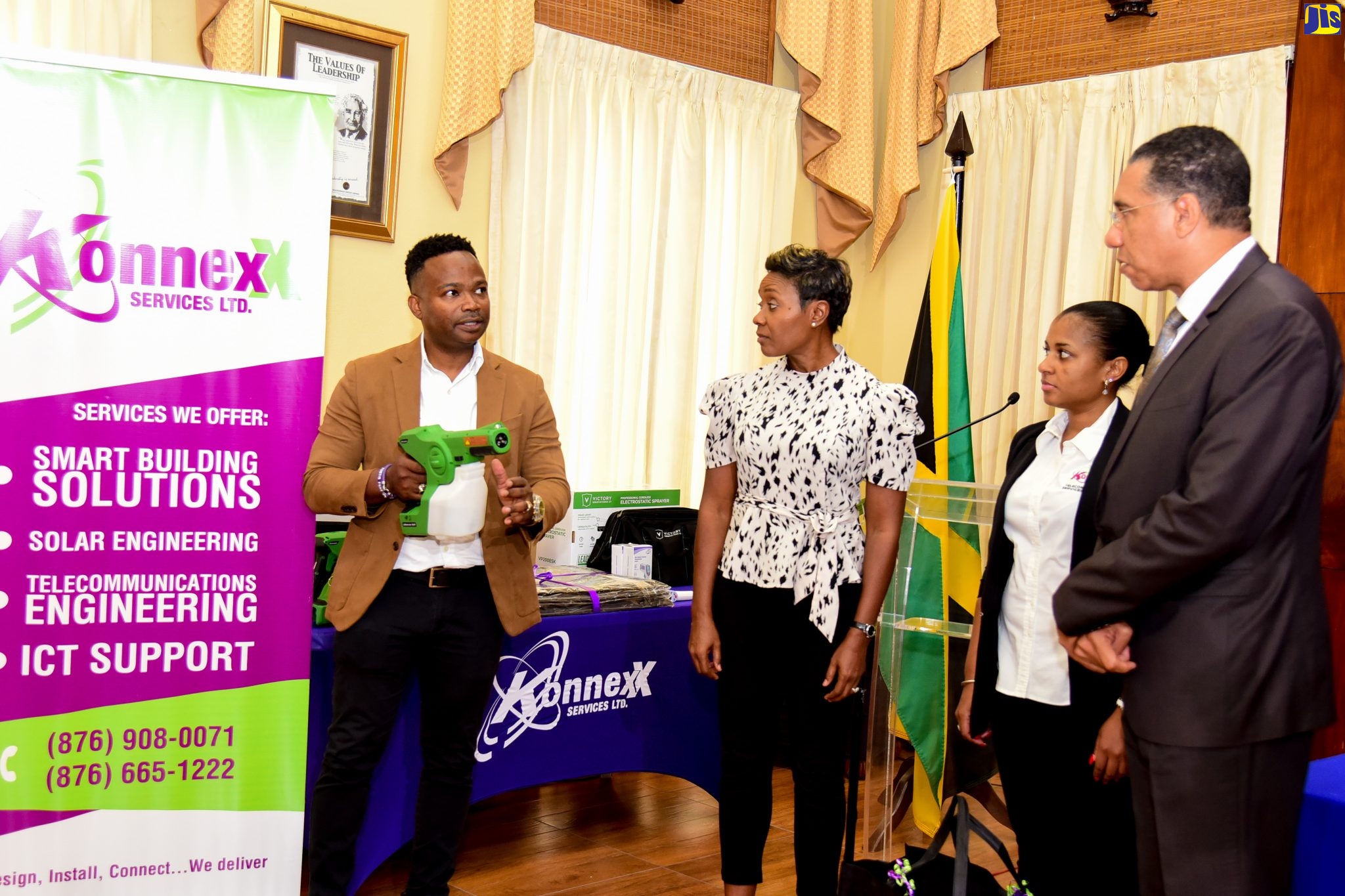 Prime Minister, the Most Hon. Andrew Holness (right) and Minister of State in the Ministry of Health and Wellness, Hon. Juliet Cuthbert Flynn (second left), are attentive as Founder and Managing Director, Konnexx Services Limited, Dean Nevers (right), explains the benefits of the electrostatic sprayer. Occasion was a ceremony for the handover of hygiene and sanitisation supplies, valued at $10.5 million, for use in 26 hospitals islandwide, at the Banquet Hall, Office of the Prime Minister on January 18. Looking on is Operations Manager, Konnexx Services Limited, Kerrie-Anne Gray. 

