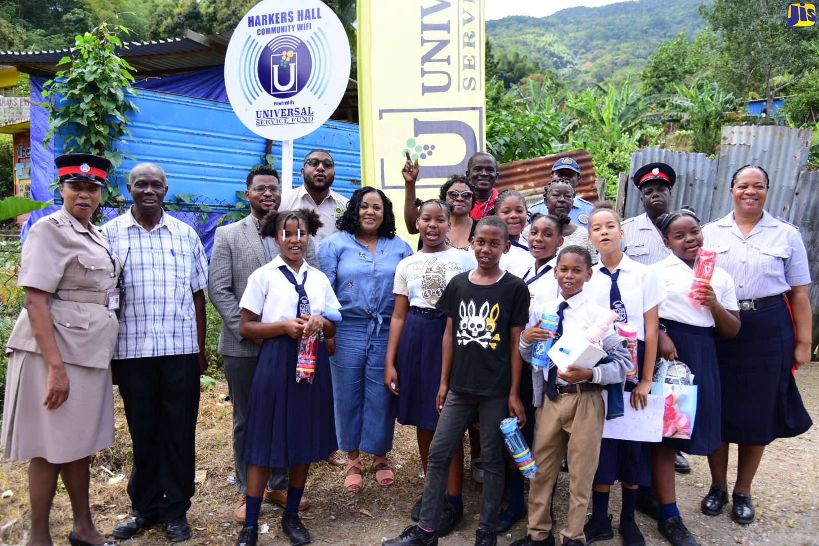 Communications Officer, Universal Service Fund (USF), Timothy Simmonds (third left), is joined by (from left) Inspector of Police, Above Rocks Police Station, Judith Pownall (left) and other members of the Jamaica Constabulary Force (JCF); Field Supervisor, Social Development Commission (SDC), Jeremy Jones (fourth left); Member of Parliament, St. Catherine North Central, Natalie Neita-Garvey (sixth left); students and residents, at the launch of free community Wi-Fi in Harker’s Hall, St. Catherine, on January 25.