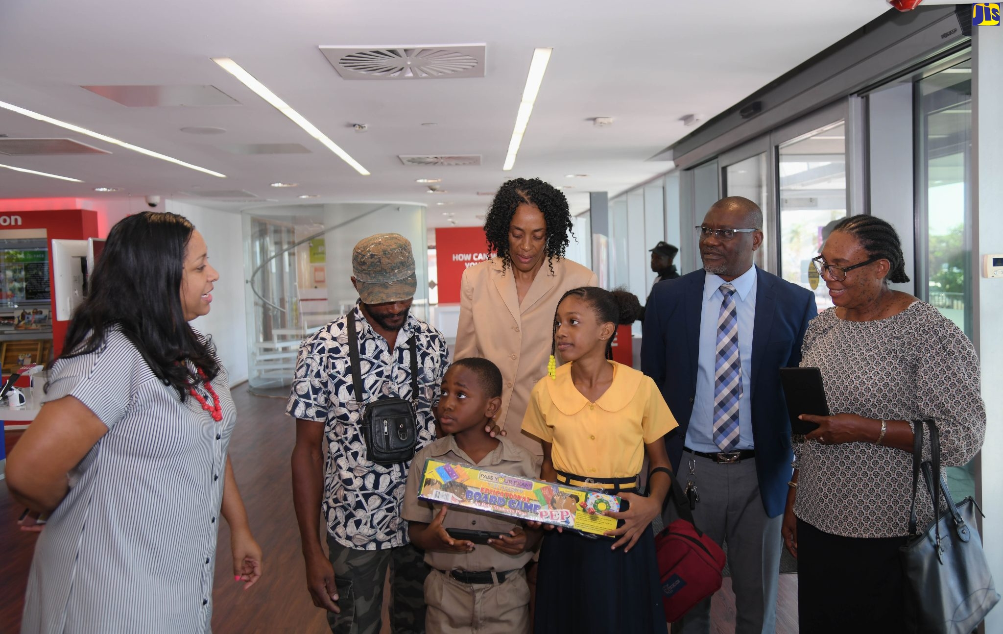 Students at the St. Mary-based Lewisburgh Primary and Infant School, Kevon Parkes and Kaylee Atkinson, listen to Chief Executive Officer of the Digicel Foundation, Charmaine Daniels (left), during a handover of grants to several institutions at the Digicel corporate headquarters in downtown Kingston, recently. Also pictured (from second left) are community member, Vivian Riley; Project Manager at the school and Founder of the Brighter Than Gold Foundation, who is also a past student at the school, Marie Hall; Principal, Paul Gobourne, and Vice Chairman of the school Board, Millicent Buchanan.