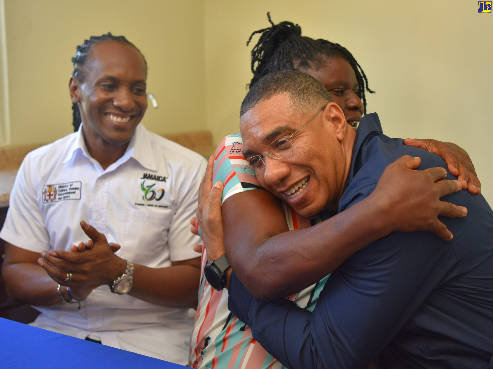 Prime Minister, the Most Hon. Andrew Holness (right) shares a hug with beneficiary under the New Social Housing Programme (NSHP), Moveta Clarke (centre) after she signed the social contract for her new three-bedroom home in Rosemary Castle, St. Catherine, during the hand over ceremony on Wednesday (Jan. 25). Sharing the moment is Member of Parliament, St. Catherine East Central, Hon. Alando Terrelonge.
