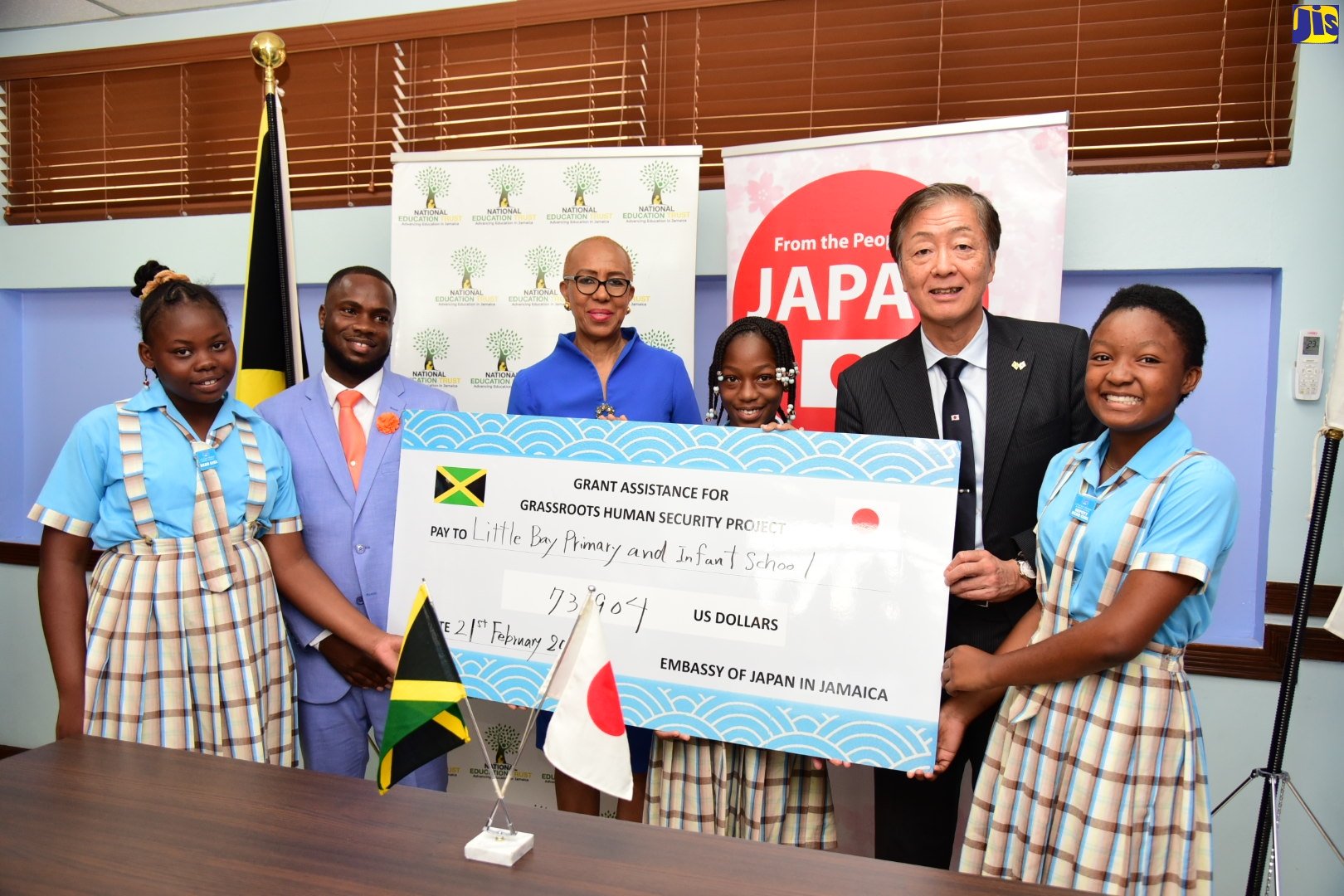 Minister of Education and Youth, Hon. Fayval Williams (third left), joins in the symbolic handover of a cheque from the Government of Japan, along with Japanese Ambassador to Jamaica, His Excellency Yasuhiro Atsumi (second right), to Little Bay Primary and Infant School in Westmoreland. The provision facilitated the purchase of a school bus for the institution. Representing the school (from left) are Head Girl, Ackecia Gayle; Principal, Keron King; Prefect, Kendra Cornwall; and Deputy Head Girl, Marieka Anderson. The presentation was made during a ceremony at the Ministry in Kingston, on Tuesday (February 21). 