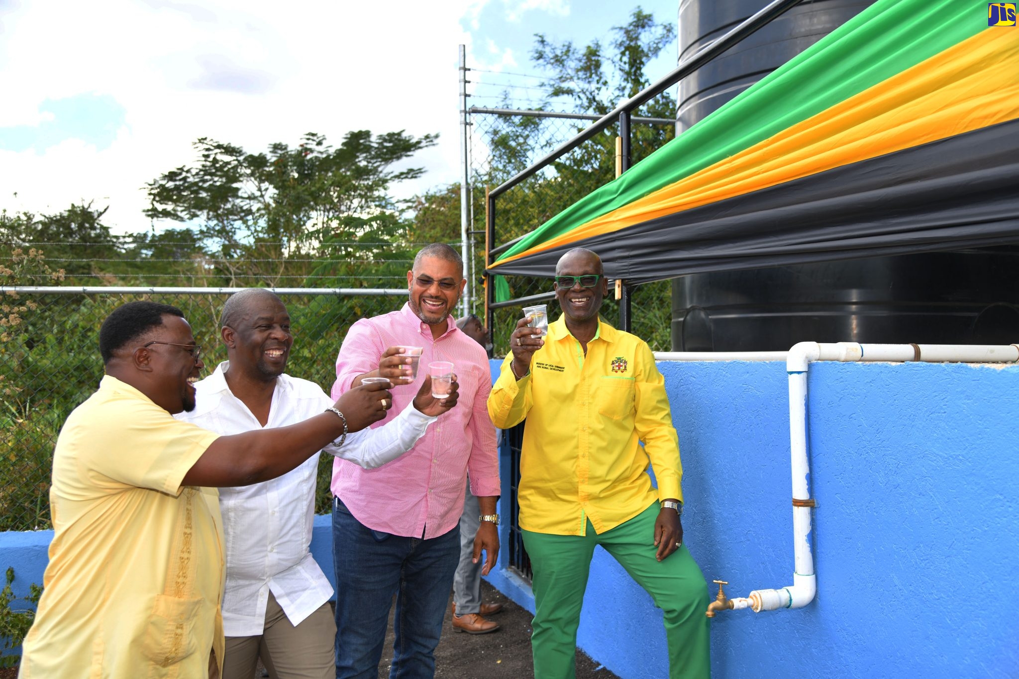 Local Government and Rural Development Minister, Hon. Desmond McKenzie (right) and (from left) Councillor for the Mile Gully Division, Rohan Kennedy; Mayor of Mandeville, Councillor Donovan Mitchell and Member of Parliament, Manchester North Western, Hon. Mikael Phillips, prepare to have a taste of water from the water shop in Mile Gully, Manchester, which opened recently.

