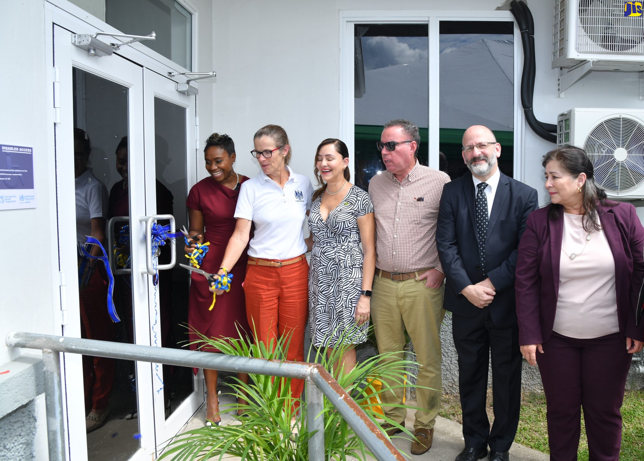 Minister of State in the Ministry of Health and Wellness, Hon. Juliet Cuthbert-Flynn (left) and British High Commissioner to Jamaica, Her Excellency Judith Slater (second left), cut the ribbon for the official reopening of the Port Antonio Health Centre in Portland on (February 17).  Sharing the moment (from third left) are Member of Parliament for Portland Eastern, Ann-Marie Vaz; Member of Parliament for Portland Western, Hon. Daryl Vaz; Representative of the Pan-American Organization (PAHO), Ian Stein and Chairman of the North-East Regional Health Authority (NERHA), Laura Heron.