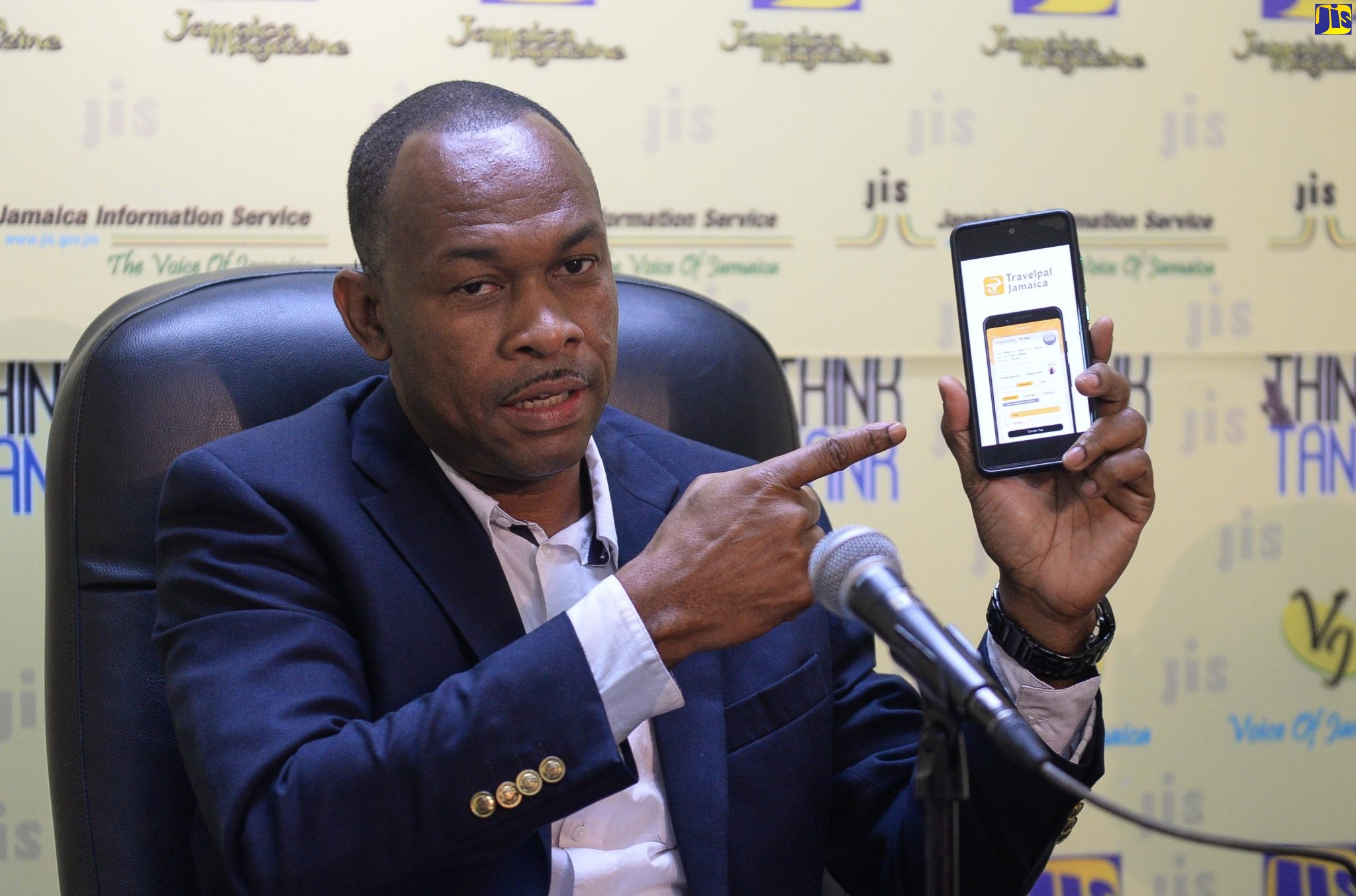 Managing Director of the Transport Authority (TA), Ralston Smith, shows an App of the organisation on a cellular phone, at a JIS ‘Think Tank’, on February 17. 