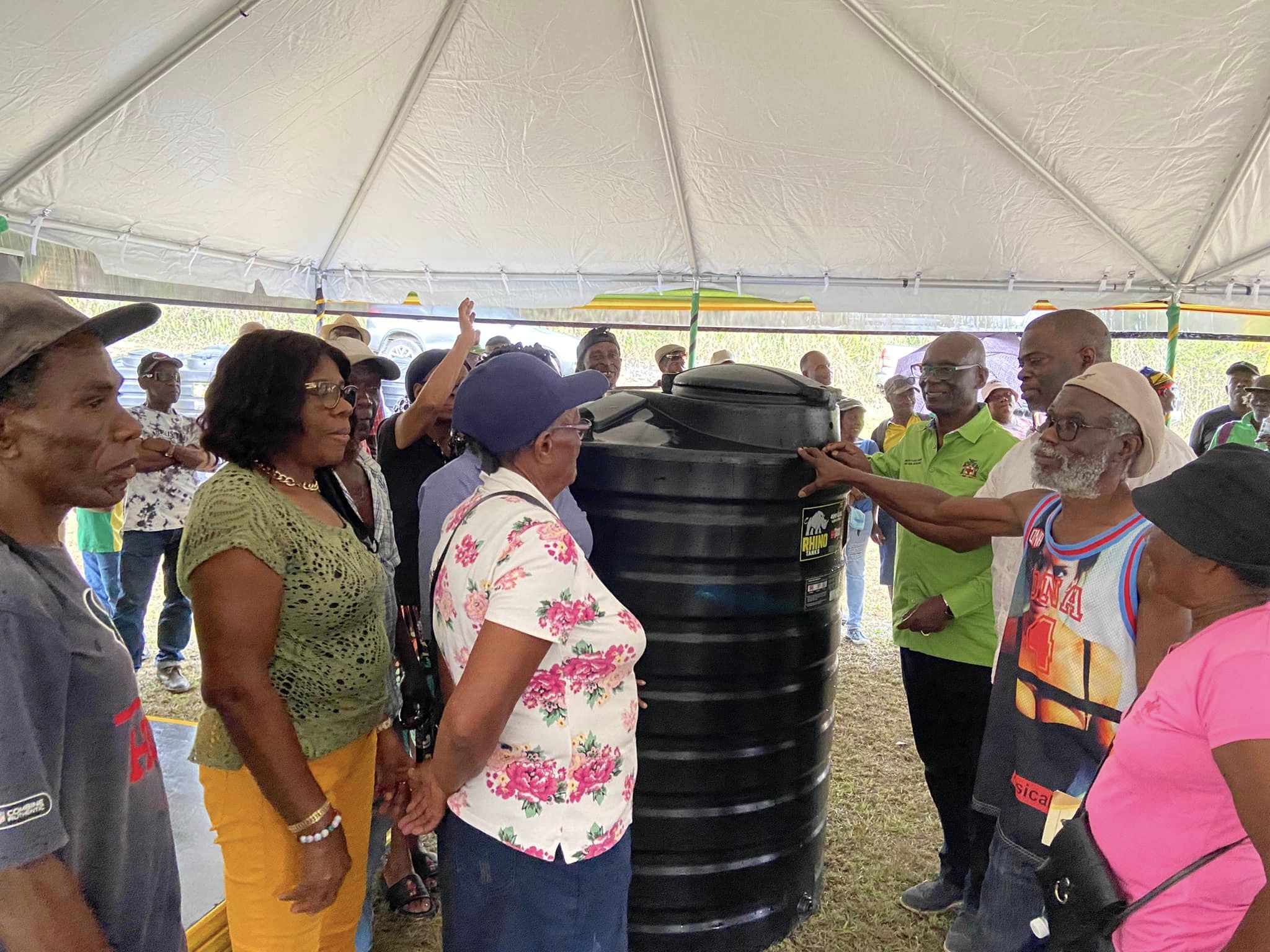Minister of Local Government and Rural Development, Hon. Desmond McKenzie (4th from right), looks at one of the 400-gallon water tanks that have been provided for residents in Chambers Pen, Hanover. Occasion was a recent visit to the community where the Minister handed over several projects that have been completed under the Rural Development Programme (RDP).
