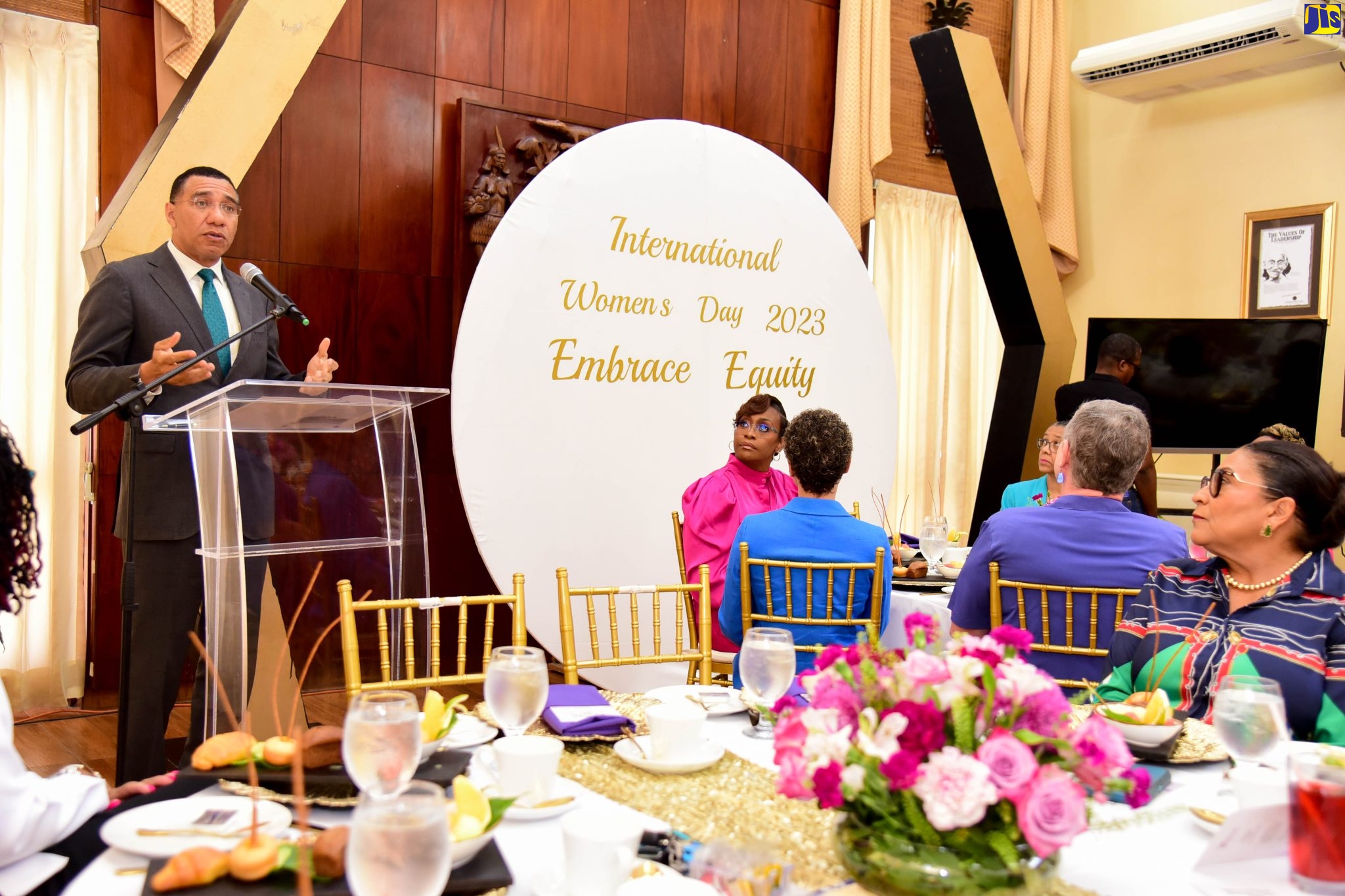 Prime Minister, the Most Hon. Andrew Holness (left), speaks at an International Women’s Day breakfast, hosted by his wife and Deputy Speaker of the House of Representatives, the Most Hon. Juliet Holness (seated,  left), at Jamaica House, in St. Andrew, on March 8.  At right is speaker of the House of Representatives, Hon. Marisa Dalrymple-Philibert.