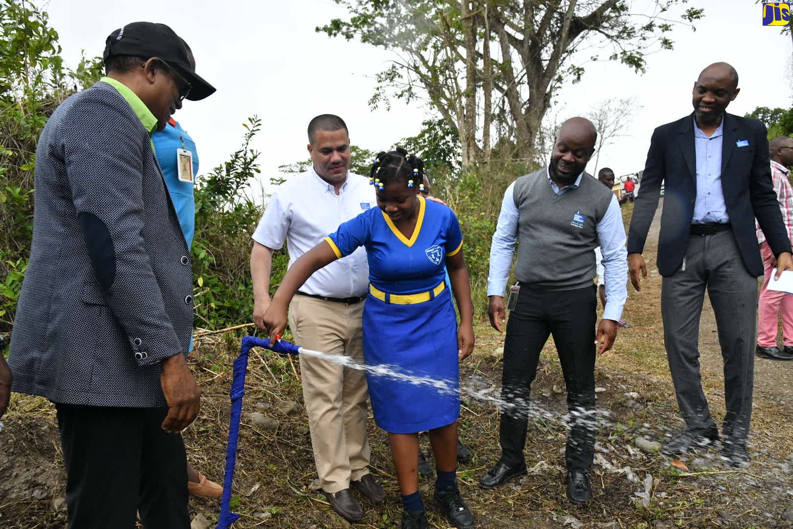 Minister without Portfolio in the Ministry of Economic Growth and Job Creation, Senator the Hon. Matthew Samuda (second left), observes as Bromley Primary School student, Hadasia Thompson, turns on a tap symbolising the commissioning into service of the Macka Hill Pipeline Replacement Project in St. Mary Southeast, on Wednesday (March 15). Also observing (from left) are: Minister of State in the Ministry of Industry, Investment and Commerce, and Member of Parliament for the area, Dr. the Hon. Norman Dunn; National Water Commission (NWC) Vice President of Operations, Herman Fagan, and Regional Manager, David Pryce.