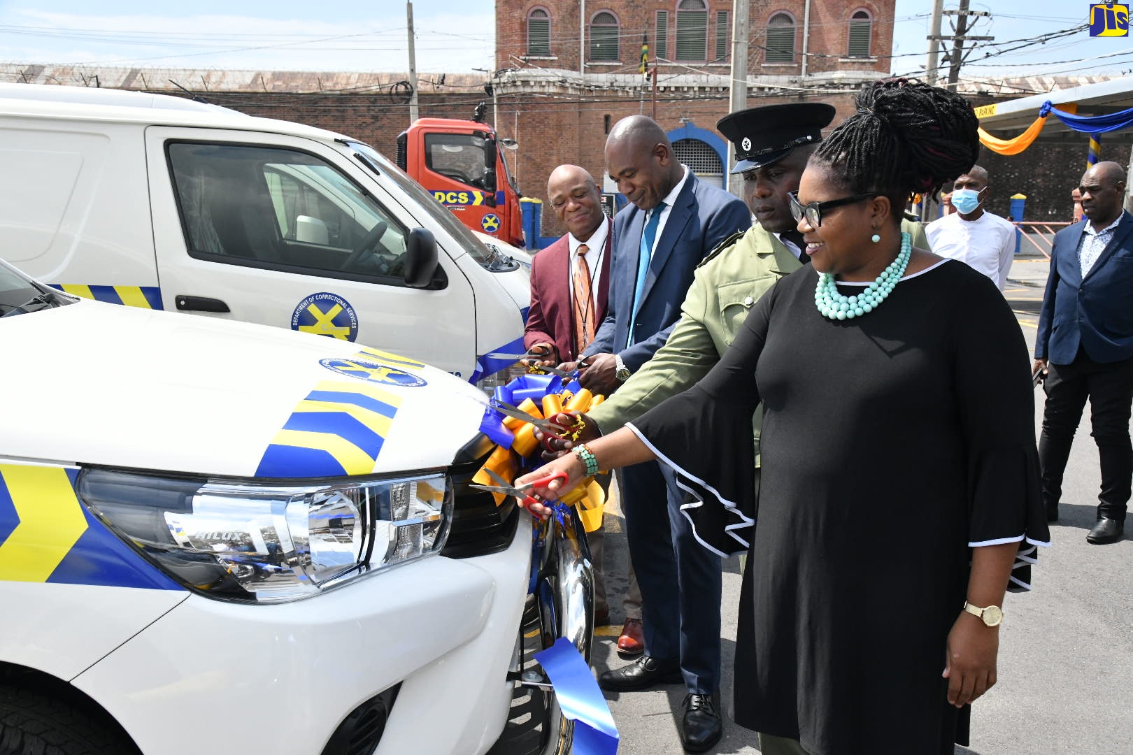 State Minister in the Ministry of National Security, Hon. Zavia Mayne (second left), cuts the ribbon for 11 new motor vehicles acquired for the Department of Correctional Services (DCS).
He is joined by (from left): Commissioner of Corrections, Lieutenant Colonel Retd. Gary Rowe; Superintendent Philbert Officer, who is in charge of the DCS Transport Centre; and Chief Technical Director in the Ministry, Shauna Trowers. Mr. Mayne inspected the vehicles  on Thursday (March 16) at the Tower Street Adult Correctional Centre in Kingston.