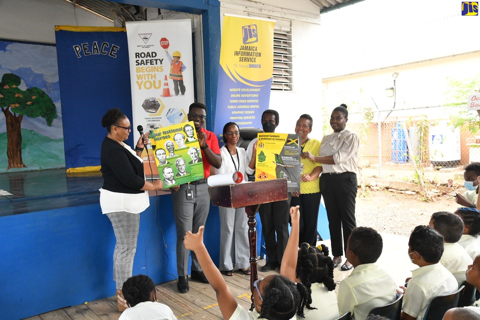 Principal of St. Hugh’s Preparatory School, Sasha Wright (left), displays an information poster depicting the Jamaica’s National Heroes during a road-safety session at the institution on Monday (March 27). The event was staged by the Jamaica Information Service (JIS) in partnership with the Road Safety Unit in the Ministry of Transport and Mining. Others (from second left) are Education and Information Officer at the Unit, Dontae Matthews; and JIS team members, Acting Managing Editor, Editorial and Photography Department, Tracey Chin Loy; Acting Senior Editor, Douglas McIntosh; Consulting Sub-Editor, Andrea Hoo Fung, and Administrative Assistant, Research, Print and Production Division, Kristen Hunt.