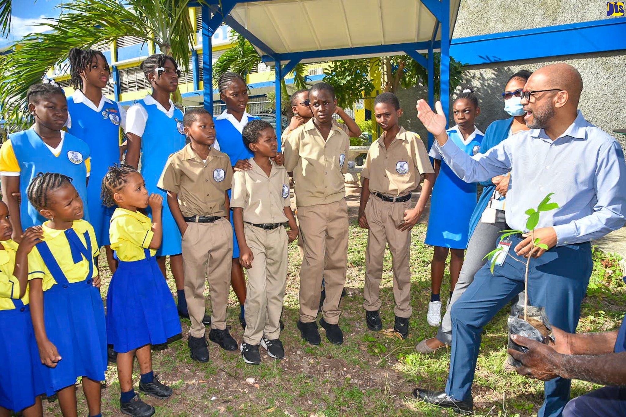 Students of the Constant Spring Primary and Infant School listen as Principal Director, Meteorological (Met) Service of Jamaica, Evan Thompson (right), talks about the importance of climate, weather and water on International Day of Forests, which was celebrated on Tuesday (March 21). With him is Head of the Met Service’s Climate Branch, Jackie Spence-Hemmings (second right).