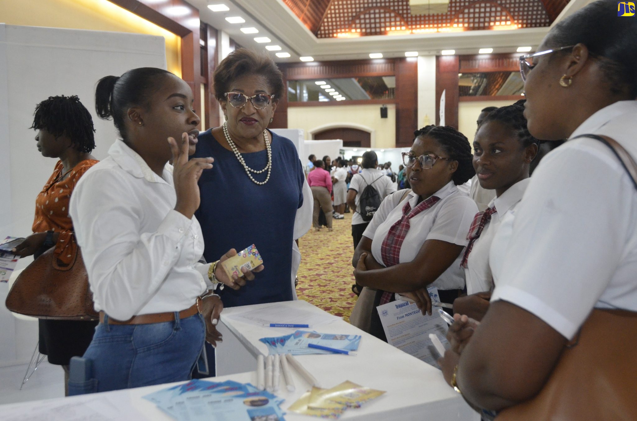 Executive Director of Jamaica Vacations (JamVac), Joy Roberts (second left), listens as Administrative/Procurement Coordinator at JamVac, Nadia White (left), discusses tourism careers with students from the Portmore Community College, at the Jamaica Centre of Tourism Innovation (JCTI) inaugural Career Expo, which was held at the Montego Bay Convention Centre in St. James, on Friday (March 3). 

