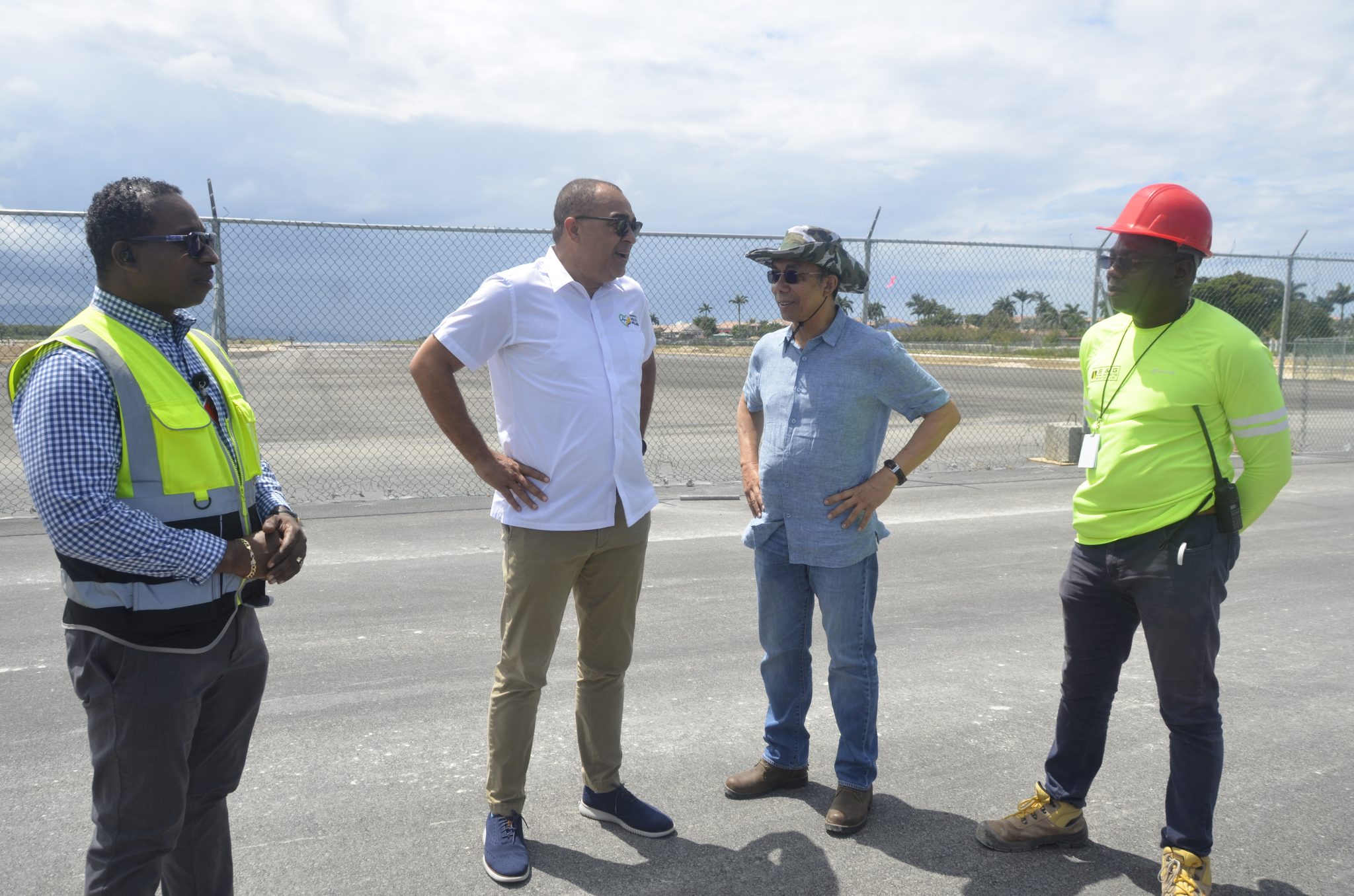 Minister of National Security, Hon. Dr. Horace Chang ( second right), speaks with Minister of Health and Wellness, Dr. the Hon. Christopher Tufton (second left), during a tour of Sangster International Airport’s (SIA) runway extension project site on Friday (March 17). They are joined by Chief Operating Officer at MBJ Airports, operators of the SIA, Peter Hall (left) and Project Manager at contracting company, Lagan S and G, Fitzroy Jones.  