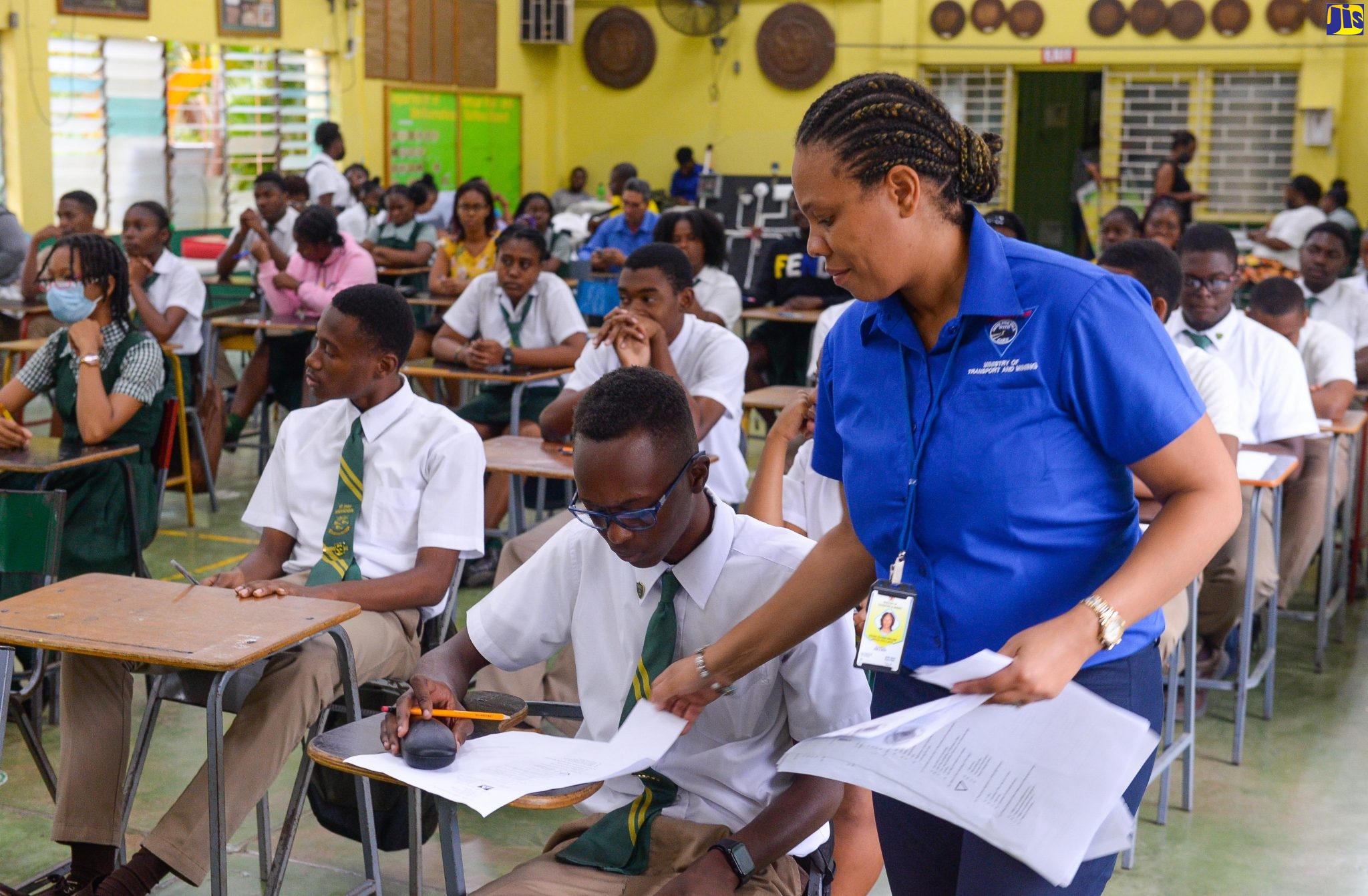 Director at the Road Safety Unit (RSU),  Deidre Hudson-Sinclair (right), assists students at the St. Jago High School in St. Catherine, during a recent examination for the road code test under the Road Safety Education in Schools Programme, administered by the RSU and the Island Traffic Authority (ITA), in the Ministry of Transport and Mining.