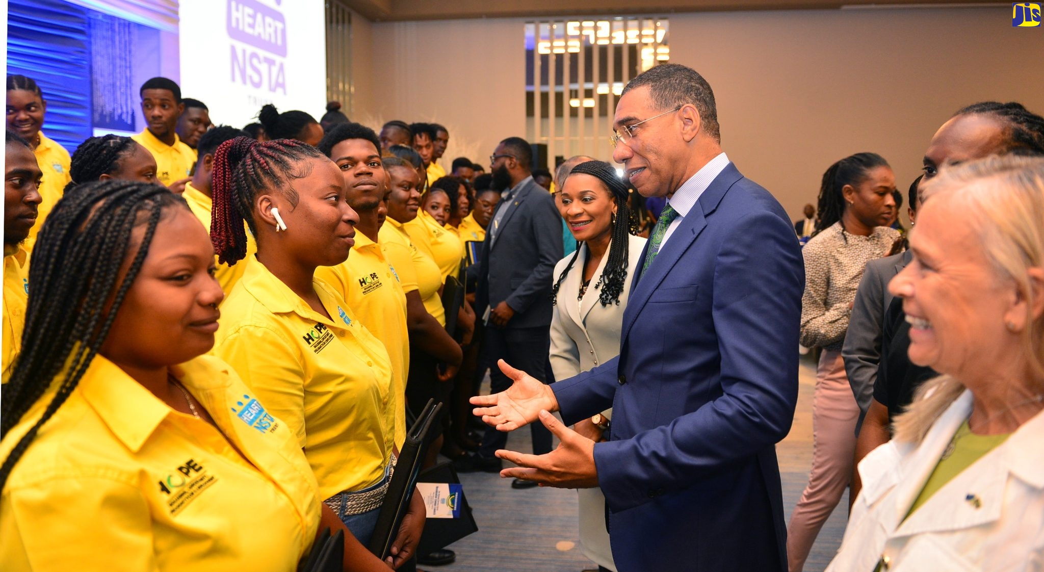 Prime Minister, the Most Hon. Andrew Holness (centre), engages with participants in the Jamaica National Service Corps Residential Camps, at the official launch of the programme on Friday (March 24), at the AC Marriott Hotel in St. Andrew. Looking on are Managing Director of the HEART/NSTA Trust, Dr. Taneisha Ingleton (left); Minister of State in the Ministry of Culture, Gender, Entertainment and Sport, Hon. Alando Terrelonge (partially hidden, second right); and Head of the European Union Delegation to Jamaica, Her Excellency Marianne Van Steen (right).