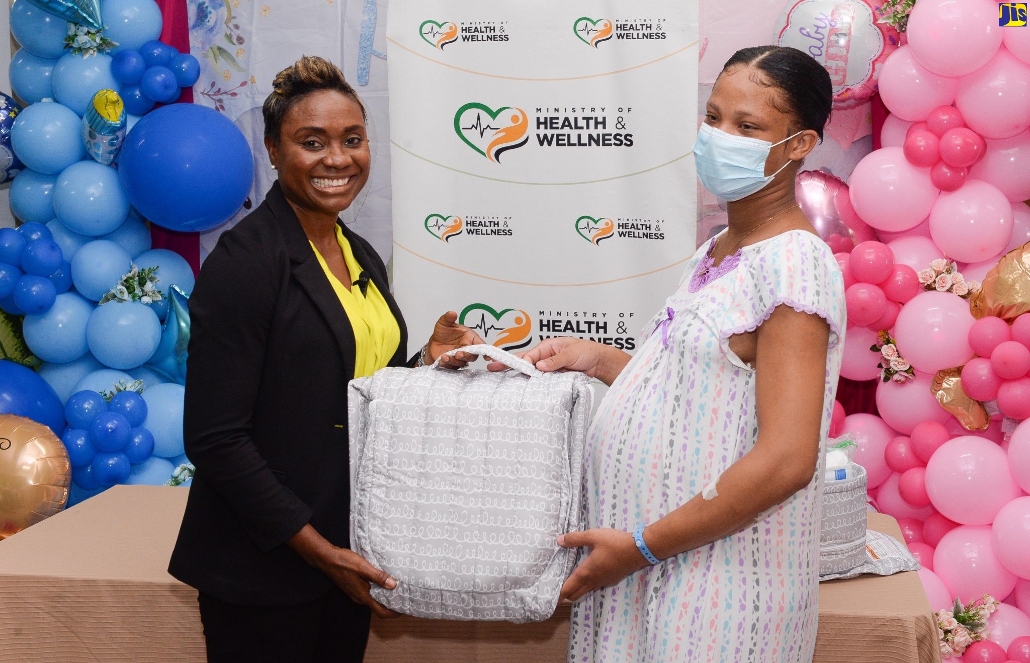 Minister of State in the Ministry of Health and Wellness, Hon. Juliet Cuthbert Flynn (left), presents maternal care supplies to Rhianna Davis during a handover ceremony at the Victoria Jubilee Hospital, downtown Kingston, on March 29. The items include snuggle nests as well as diapers and skincare and hygiene products. The presentation falls under the Start Right initiative, targeted at vulnerable mothers and their newborns, and involves collaboration among the Ministry, the American Friends of Jamaica (AFJ), and the Jamaicans Abroad Helping Jamaicans at Home (JAHJAH) Foundation. A total of 60 mothers at the facility benefited from the support.