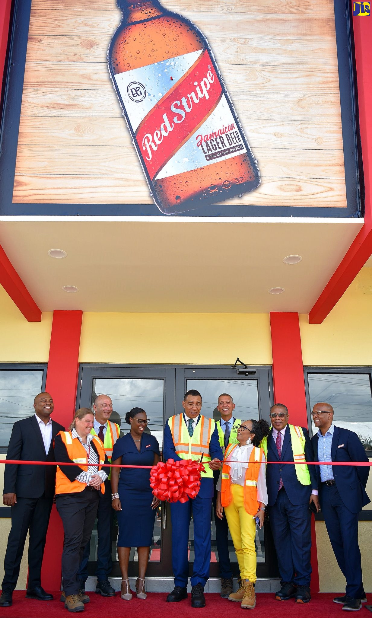 Prime Minister, the Most Hon. Andrew Holness (centre), cuts the ribbon to the upgraded Red Stripe House on Tuesday (March 28) at the plant’s Spanish Town Road location in Kingston. Participating in the exercise (from left) are Head of Human Resources, Red Stripe, Judon Bowden; Supply Chain Director, Nele Vanbeneden; Managing Director, Luis Prata; Finance Director, Yaniece Gentles; Chairman, Peter Melhado; Head of Corporate Affairs, Dianne Ashton- Smith; Member of Parliament for St. Andrew Western, Anthony Hylton and Head of Commerce, Sean Wallace. The ceremony featured the official launch of the new Red Stripe Cellars Expansion for Beer Production (CERS) project.
