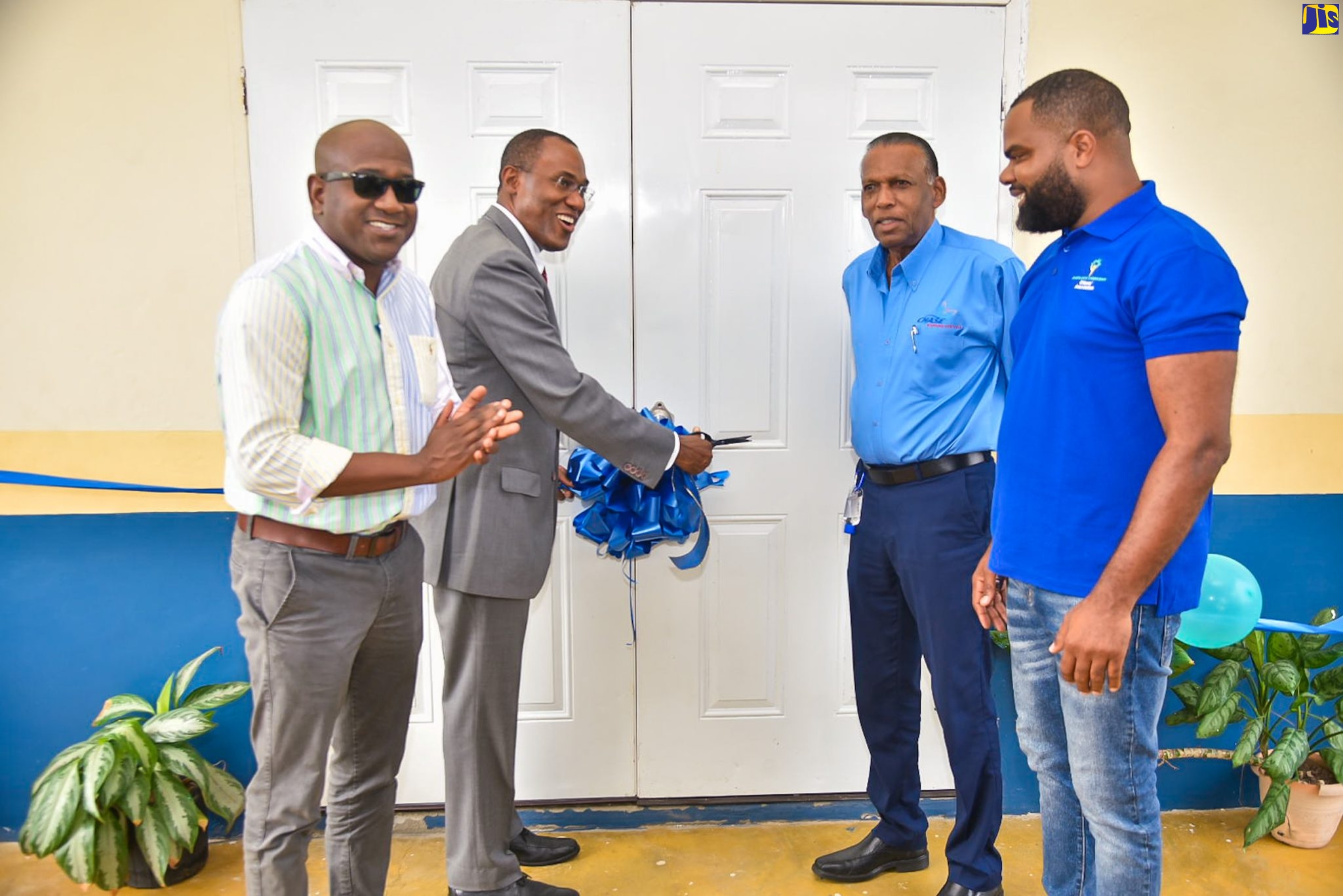 Minister of Finance and the Public Service and Member of Parliament for St. Andrew North Western, Dr. the Hon. Nigel Clarke (second left), cuts the ribbon to officially open the Sherlock Community Cultural Centre in Kingston, on Thursday (April 20). Other participants are Councillor, Chancery Division, Duane Smith; Chief Executive Officer, Culture, Health, Arts, Sports and Education (CHASE) Fund, W. Billy Heaven, and President, Sherlock Citizens Association, Toushane Green.