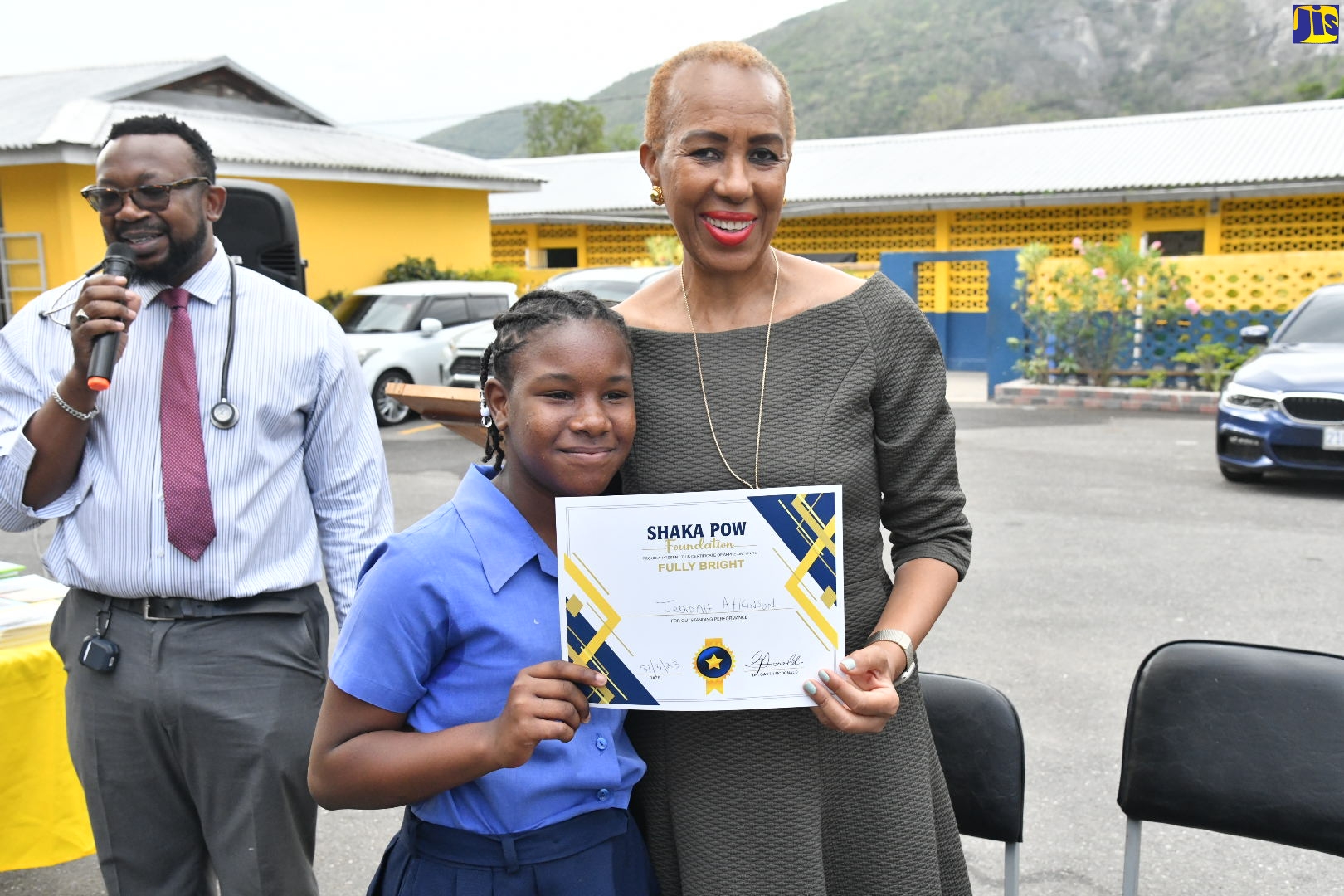 Minister of Education and Youth, Hon. Fayval Williams (right), presents the Shaka Pow Foundation’s Fully Bright certificate to student of August Town Primary School, Jedidah Atkinson (centre). Occasion was a visit by the Foundation to the school on Friday (March 31), to recognise students who are achieving excellence. At left is Founder of the Foundation and Medical Doctor, Dr. Garth “Shaka Pow” McDonald. 