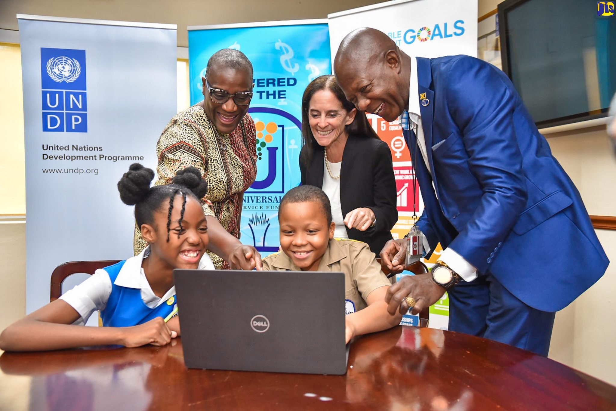 Grade-six students at Constant Spring Primary School in St. Andrew, Romiah Jule (left, seated) and Stephen Dennis (right, seated) are assisted by (from left) United Nations Development Programme (UNDP) Resident Representative, Denise Antonio; Deputy Regional Director, UNDP Latin America and the Caribbean, Linda Maguire; and Chief Executive Officer, Universal Service Fund (USF), Daniel Dawes, to navigate a computer software. The event was the closing ceremony for the Advancing Jamaica’s Digital Response to COVID-19 Rapid Finance Facility (COVID-RFF) Project on Wednesday (April 19), at the UNDP’s Kingston office. 