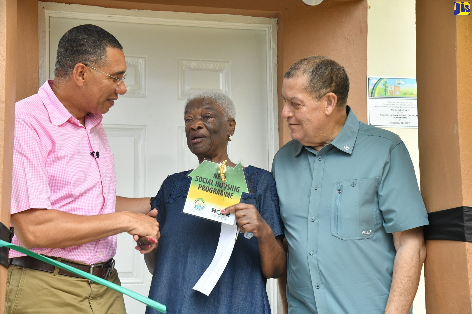 Prime Minister the Most Hon. Andrew Holness (left), hands over the key to a new two-bedroom house to new homeowner, Anette Peart (centre), during a ceremony held in Devon, Manchester on April 14. Looking on is Member of Parliament for Manchester North East, Hon. Audley Shaw. The unit was built under the New Social Housing Programme (NSHP).