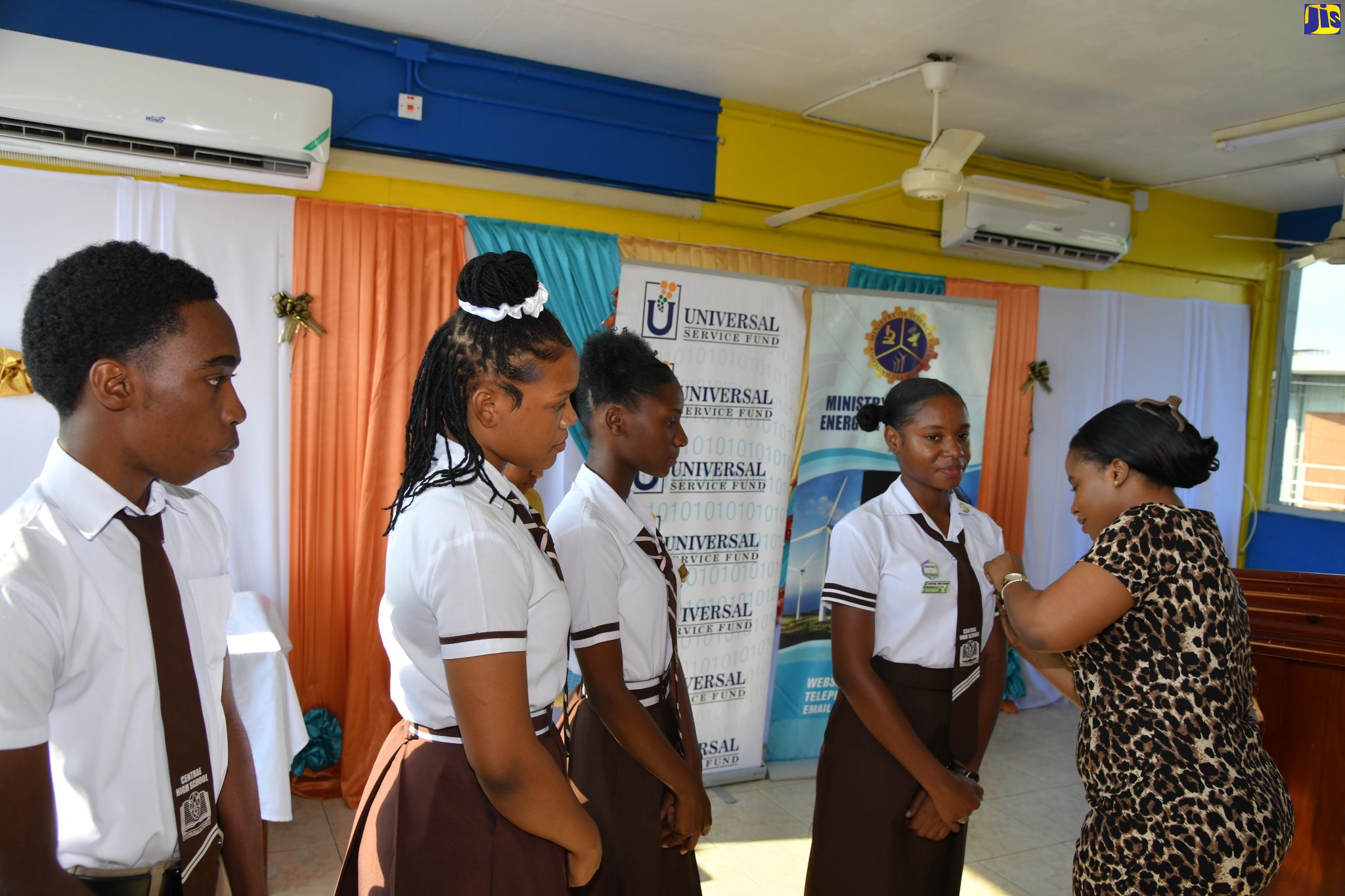 Legal Officer at the Universal Service Fund (USF), Latona Stewart (right), pins student and member of the USF ICT Club at Central High School in May Pen, Clarendon, Sania Smith (second right). Occasion was the recent launch of the group. Other members (from left) are Kajaun Haynes, Rihanna Barrett, and Riana Harris, who is also Treasurer of the group.