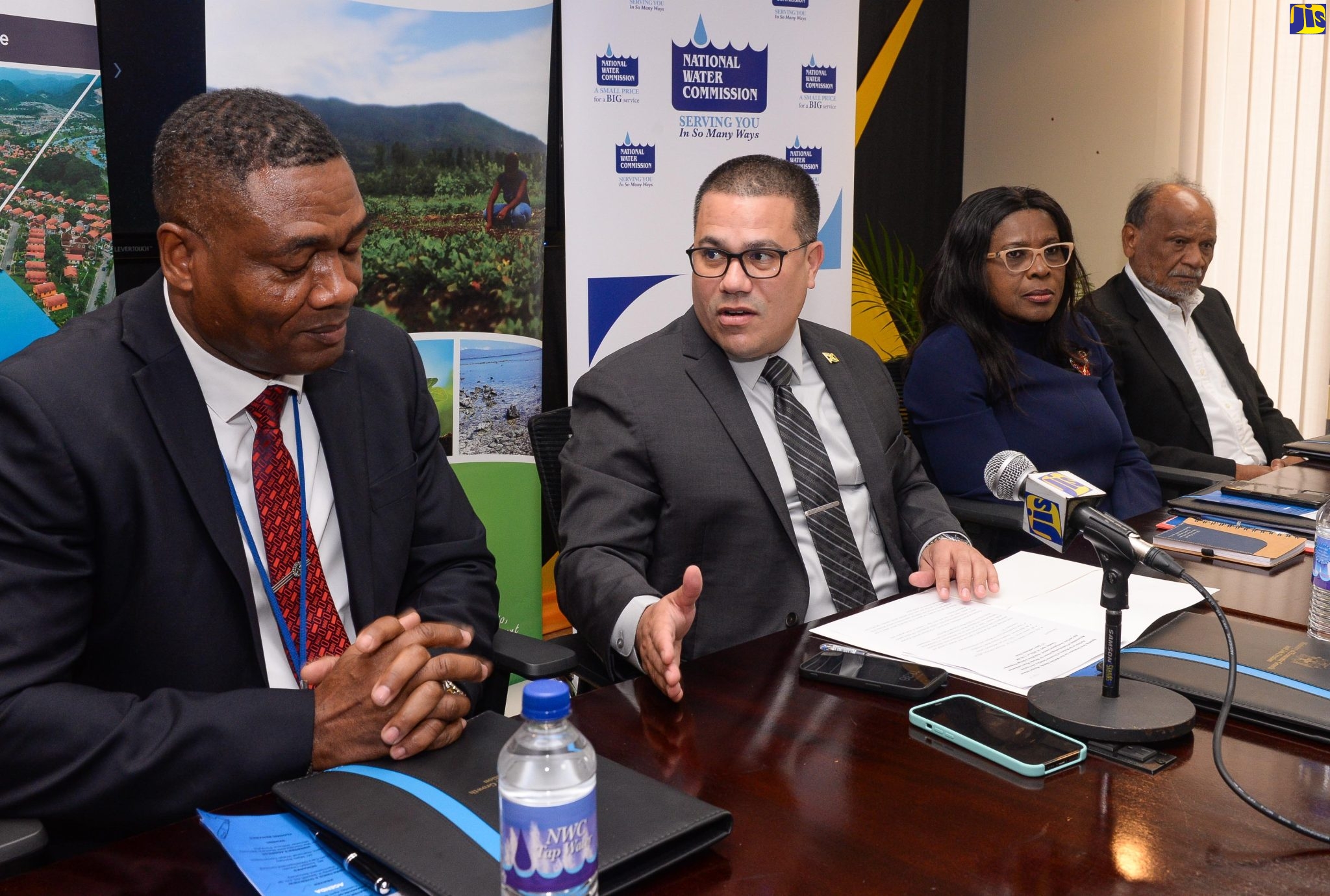 Minister without Portfolio in the Ministry of Economic Growth and Job Creation, Senator the Hon. Matthew Samuda (second left), makes a point to President of the National Water Commission (NWC), Mark Barnett (left), during the signing of a memorandum of understanding (MOU)  between the NWC and Can-Cara Development Limited (CDL) for the supply of bulk water, sewerage and irrigation services for St. Catherine South East.  Looking on (from left) are Permanent Secretary in the Ministry,  Audrey Sewell and Chairman of CDL, Joseph Lincoln. The MOU was signed at the Ministry’s Dominica Drive offices in New Kingston on Tuesday (April 18).