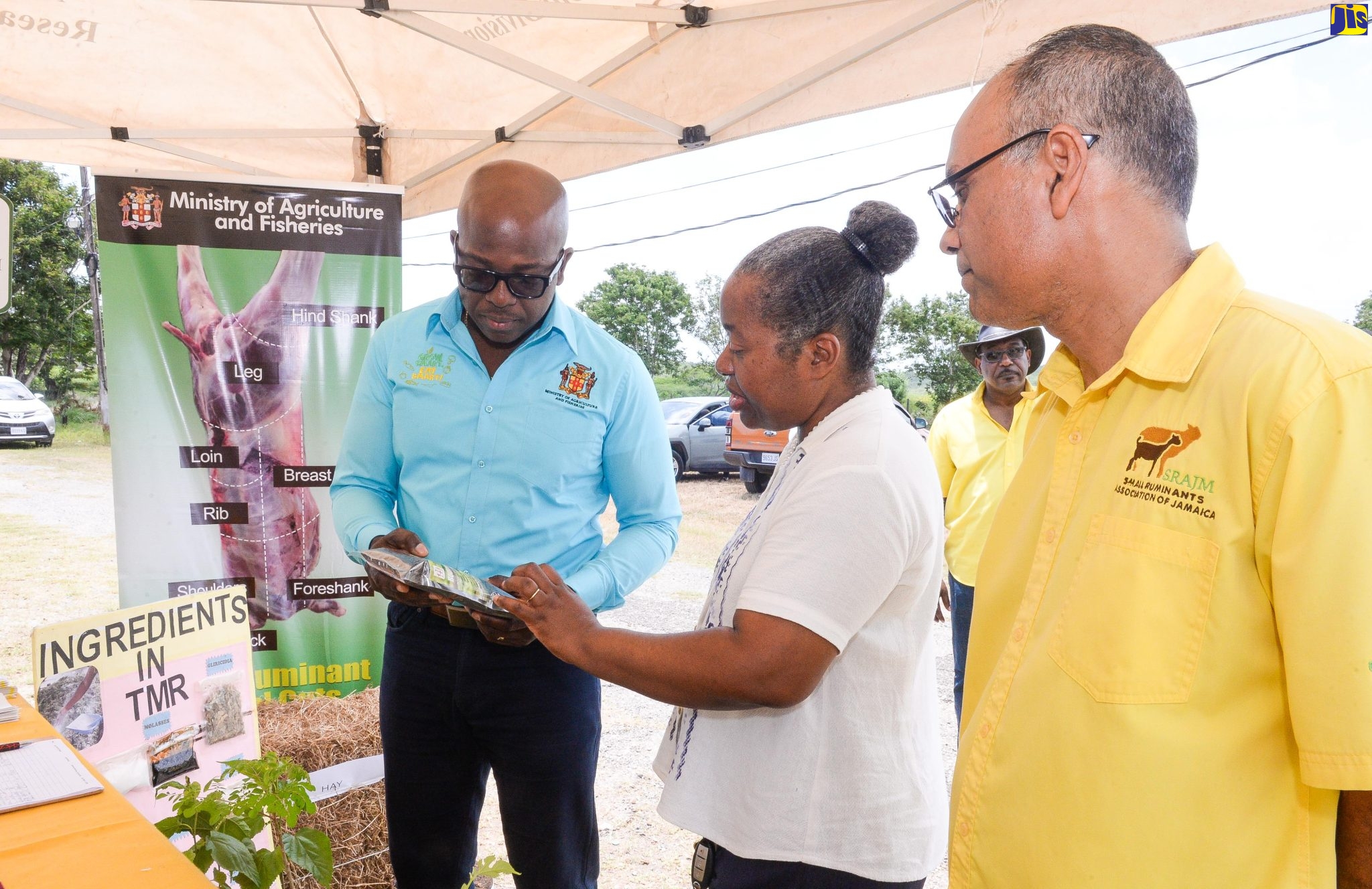 Minister of Agriculture and Fisheries, Hon. Pearnel Charles Jr. (left), listens as Principal Research Director, Bodles Research Station, Dr. Lisa Myers-Morgan (second left), explains the benefits of the animal complete feed ration or Total Mix Ration (TMR). The event was the Small Ruminants Association of Jamaica (SRAJM) Annual General Meeting on Thursday, April 20 at the Bodles Research Station, Old Harbour, St. Catherine. Looking on is President, SRAJM, Trevor Bernard.