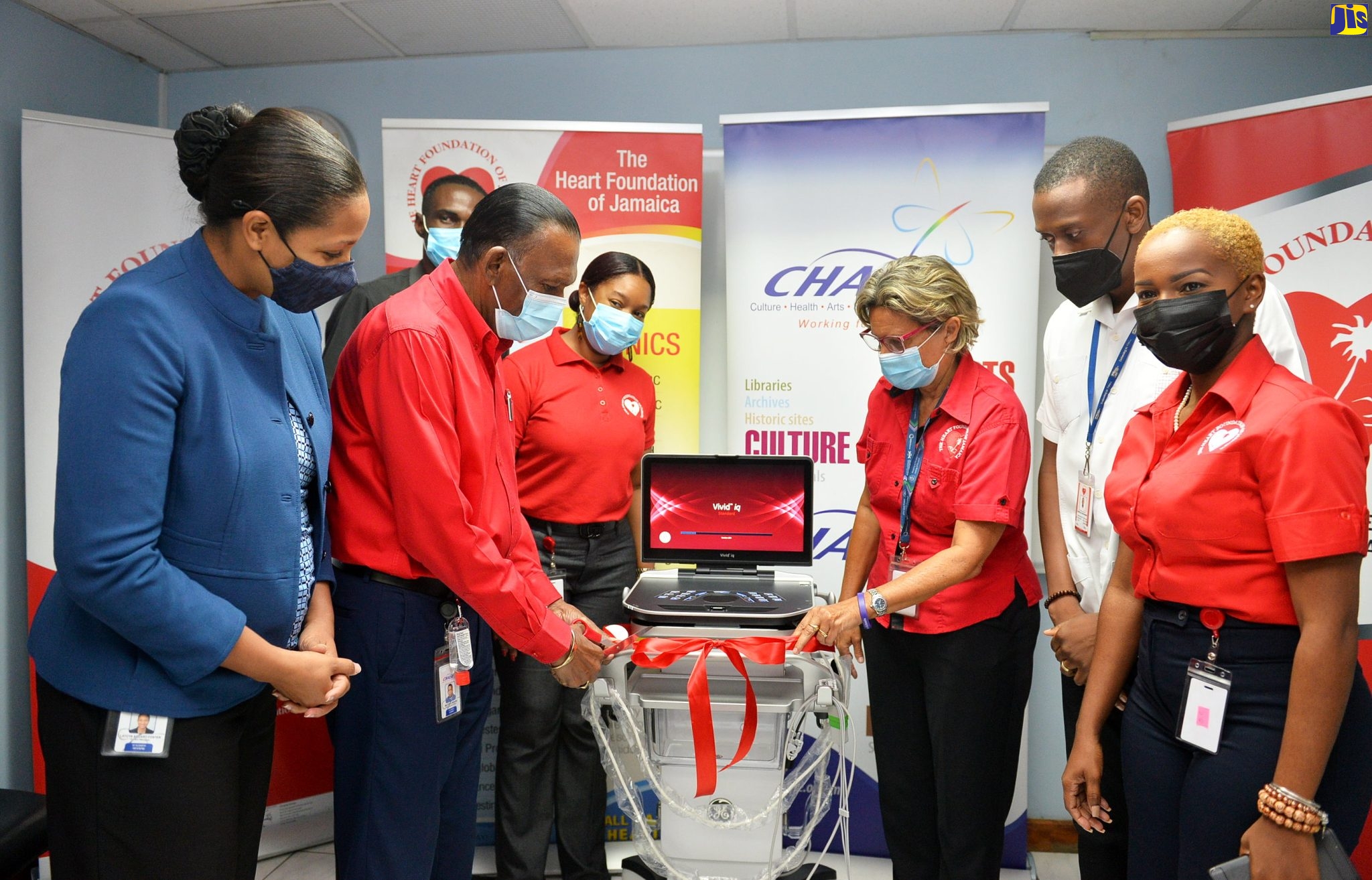 Chief Executive Officer, Culture, Health, Arts, Sports and Education (CHASE) Fund, Wilford “Billy” Heaven (second left) and Executive Director, Heart Foundation of Jamaica (HFJ), Deborah Chen (third left), perform a symbolic ribbon-cutting exercise during Thursday’s (April 13) handover ceremony for a new echocardiogram (ECG) machine. The machine was donated to the HFJ by the CHASE Fund. Other participants are (from left) CHASE Fund Project Manager, Latoya Aquart-Foster and HFJ representatives – Senior Manager, Marketing and Business Development, Krystle Daley; Cardiovascular Technician, Carlisle Richards and Chief Administrative Officer, Saccherine Chin.