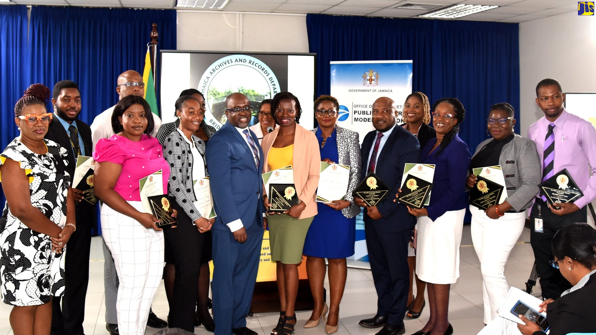 Acting Principal Director, Information Division, Office of the Prime Minister, Damian Cox (fourth left, front row), with representatives of entities that have successfully implemented the manual component of the new Government of Jamaica RIM programme. They were presented with certificates of achievement and plaques at the official launch of Records and Information Management (RIM) Month 2023, at the Planning Institute of Jamaica (PIOJ) in Kingston, on April 5.  