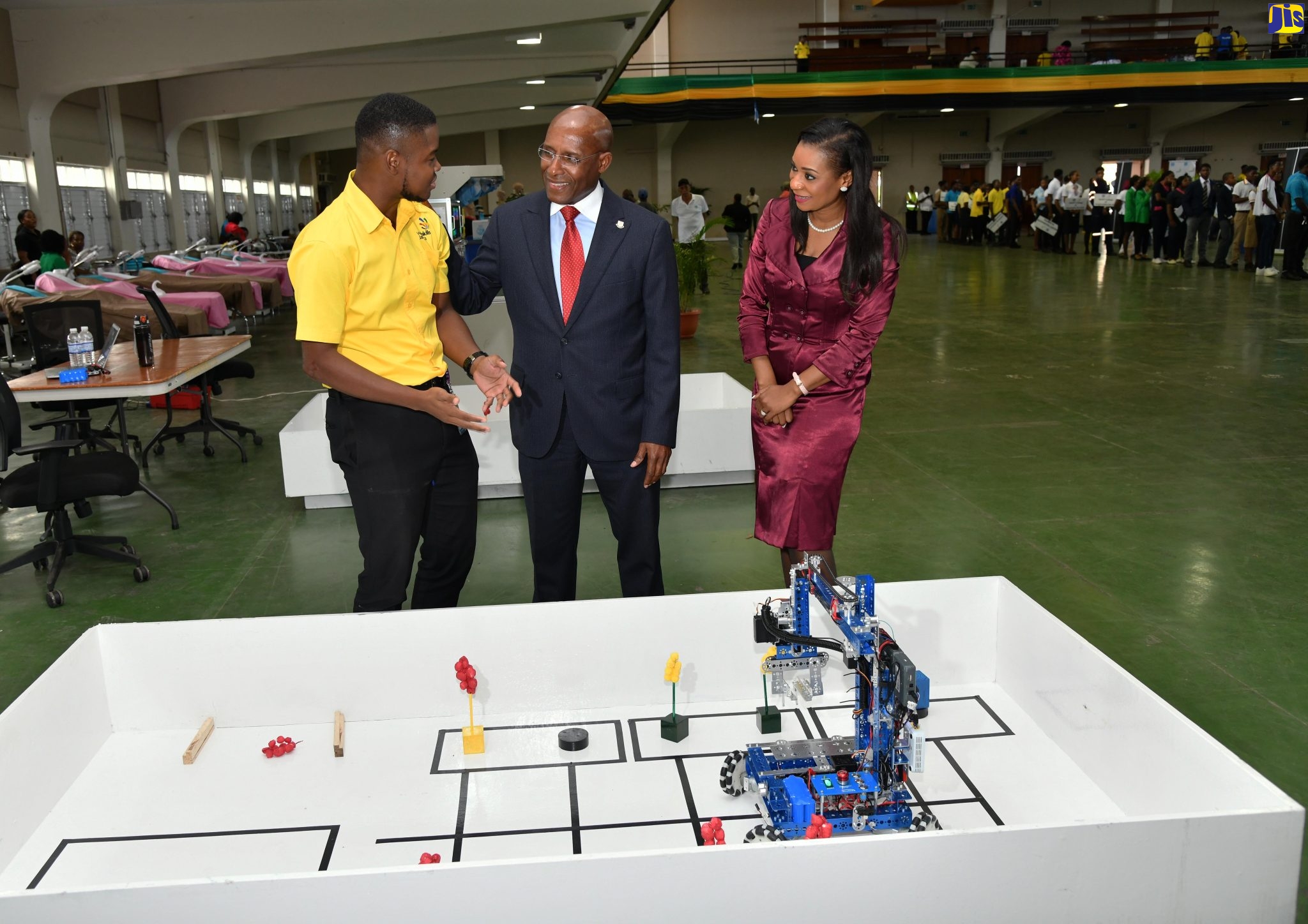 Minister of Industry, Investment and Commerce, Senator the Hon. Aubyn Hill (centre), speaks to Instructor at the HEART/NSTA Trust, Dihanroy Mitchell (left), about a robotics display at the opening of the WorldSkills National & Junior Skills Competition on Tuesday (May 30), at the National Arena in St. Andrew. Looking on at right is Managing Director of the HEART/NSTA Trust, Dr. Taneisha Ingleton.
